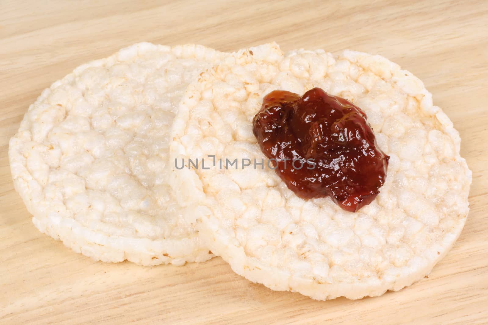 Close-up of two rice cakes with jam on a wooden background for an healthy breakfast
