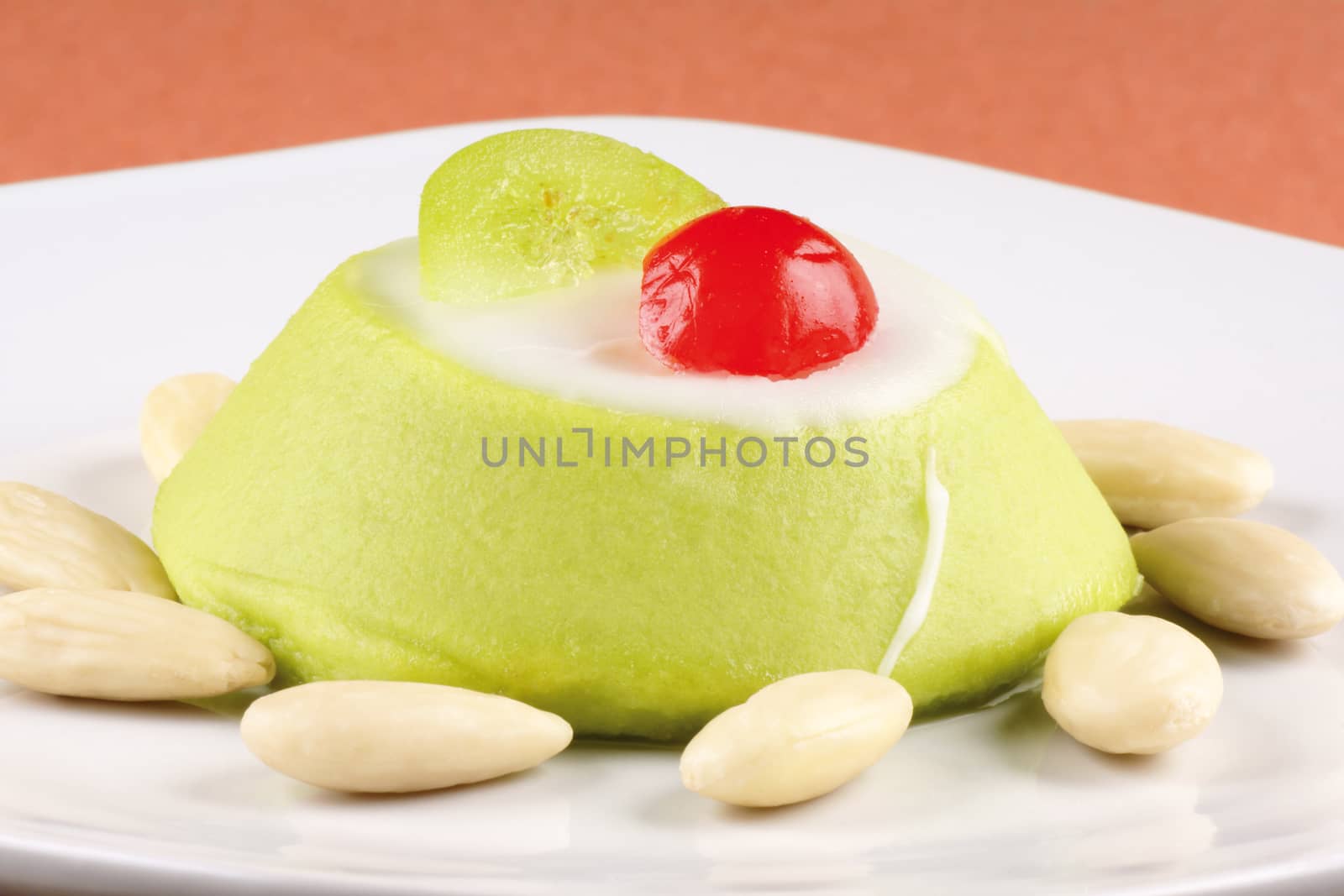 Miniature of a sicilian cassata with almonds on a white plate