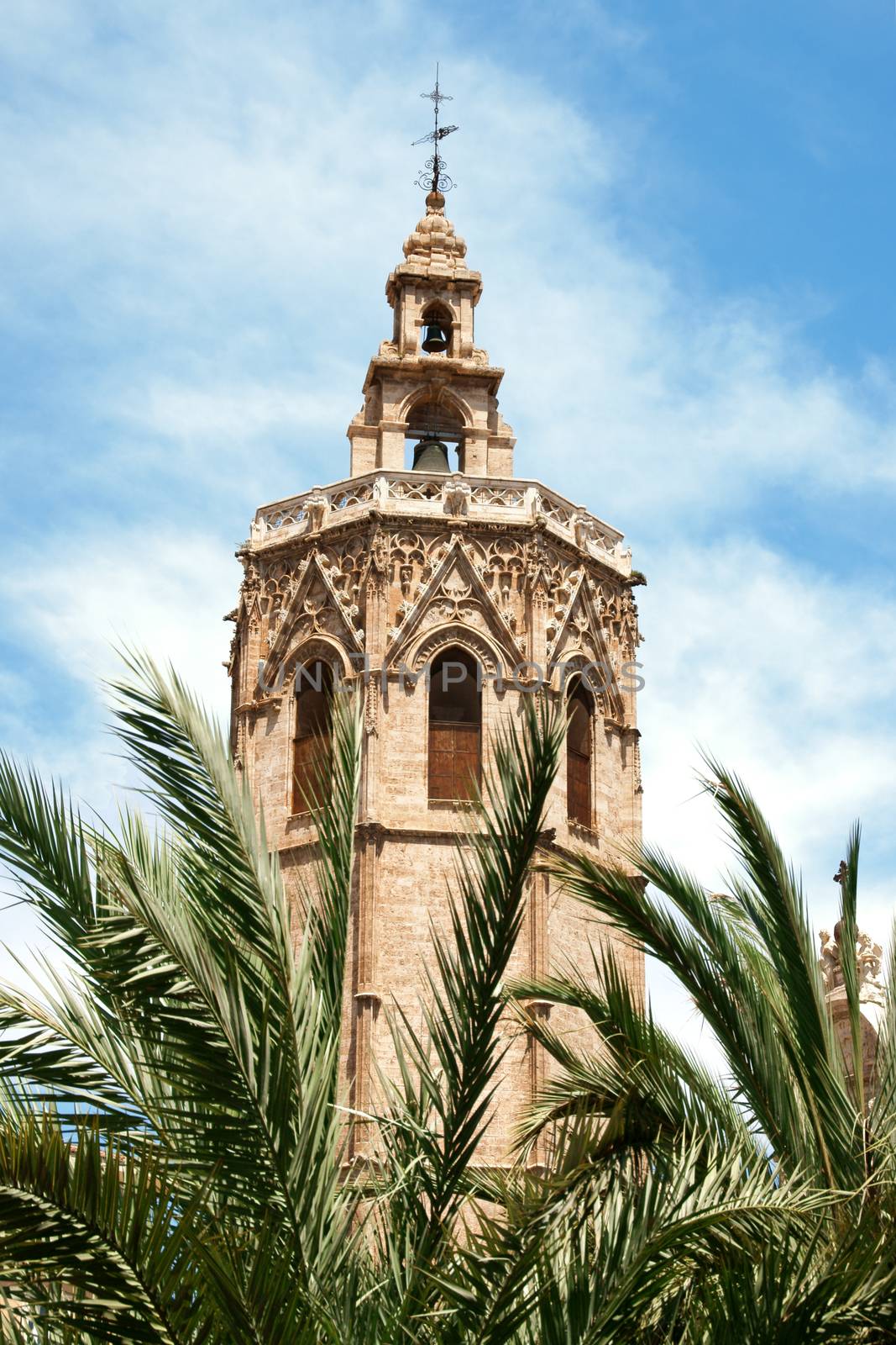 El Miguelete, the gothic bell tower of Valencia Cathedral in Spain, among palms. The Cathedral was built between 1252 and 1482 on the site of a mosque and previosly a roman temple dedicated to Diana.