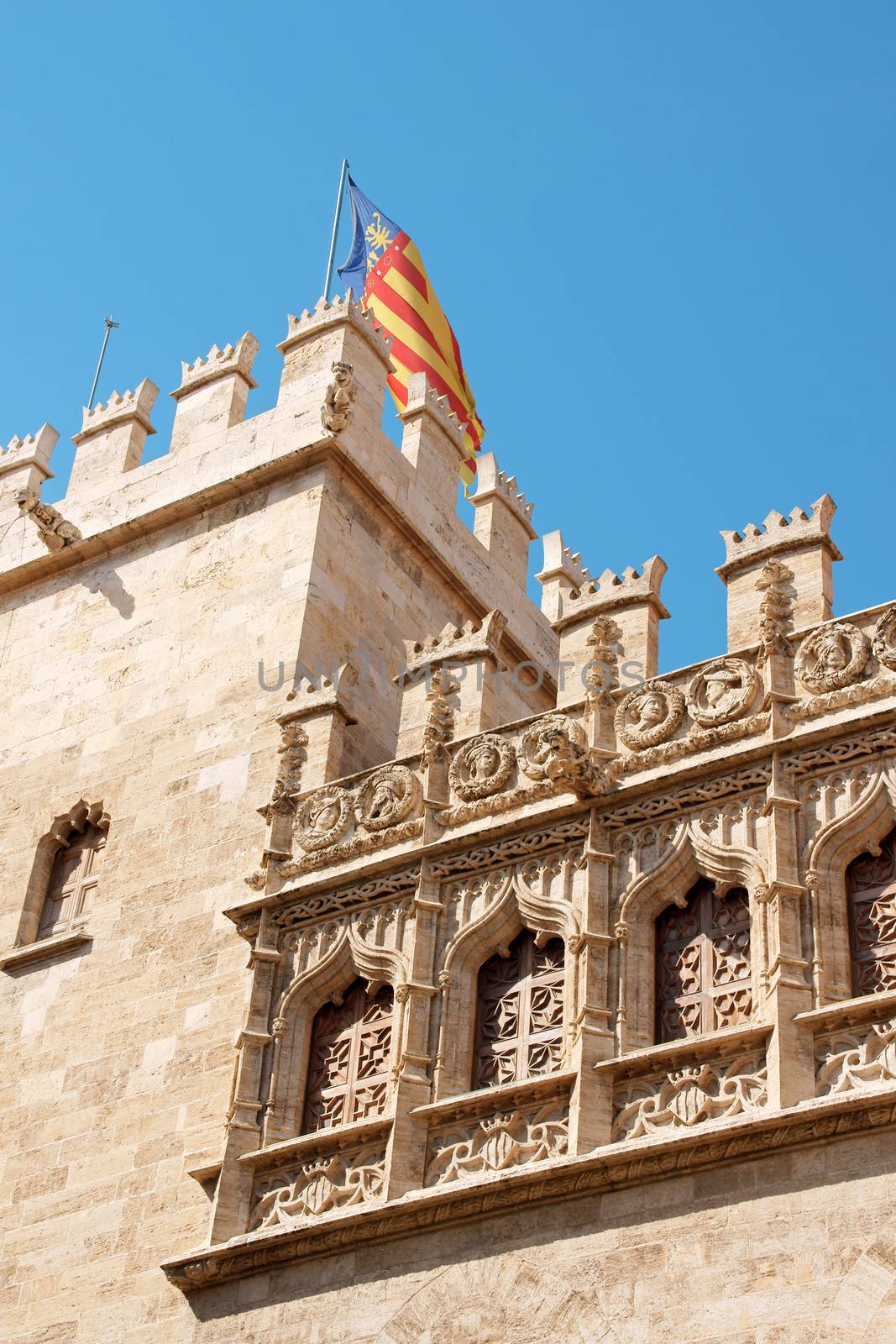 Detail of the Lonja de la Seda of Valencia in Spain and the valencian flag. This small complex of late gothic buildings, originally was used to trade silk. From 1996 it's part of UNESCO World Heritage Sites.