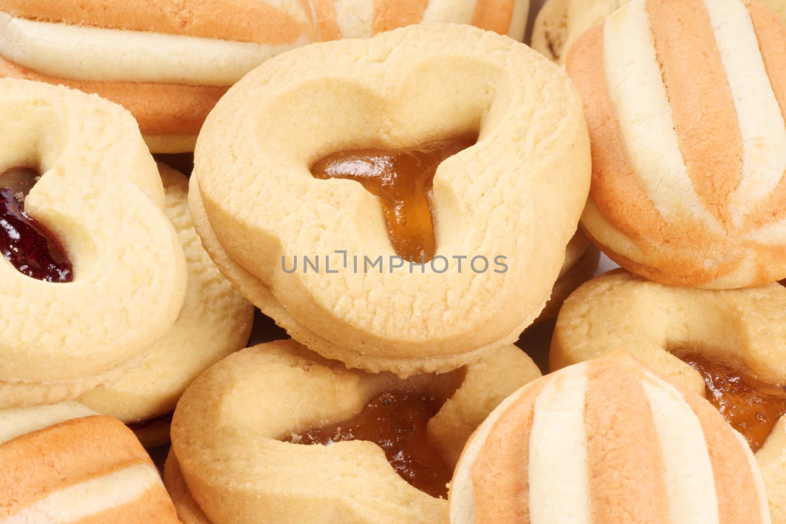 Close-up of some mixed shortcrust pastry biscuits with apricot and plum jam.