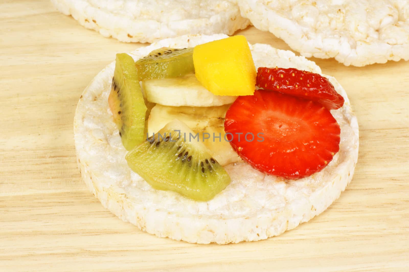 Rice cake with fresh fruit over a wooden background