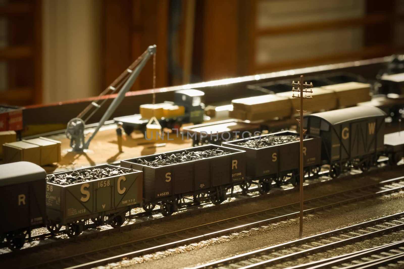 vintage toned model coal wagons backlit by sunlight