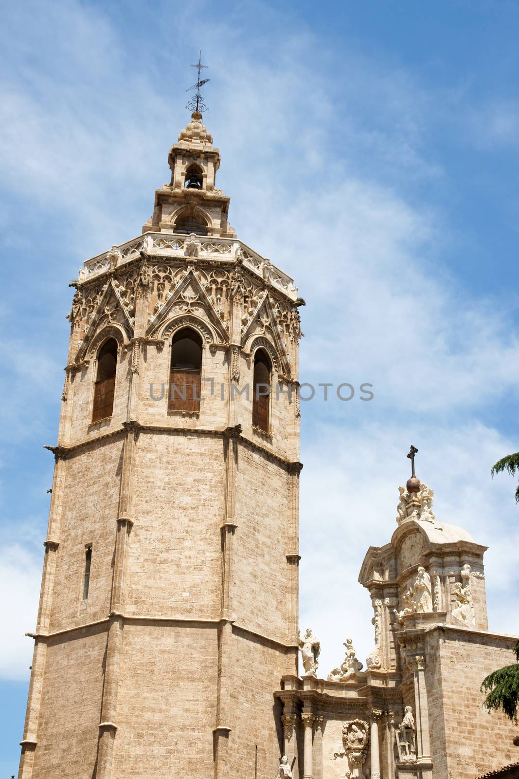 El Miguelete, the gothic bell tower of Valencia Cathedral in Spain, among palms. The Cathedral was built between 1252 and 1482 on the site of a mosque and previosly a roman temple dedicated to Diana.