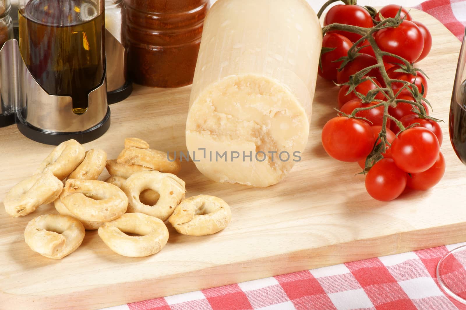 Parmesan cheese, cherry tomatoes and taralli from south Italy served on a wooden cutting board