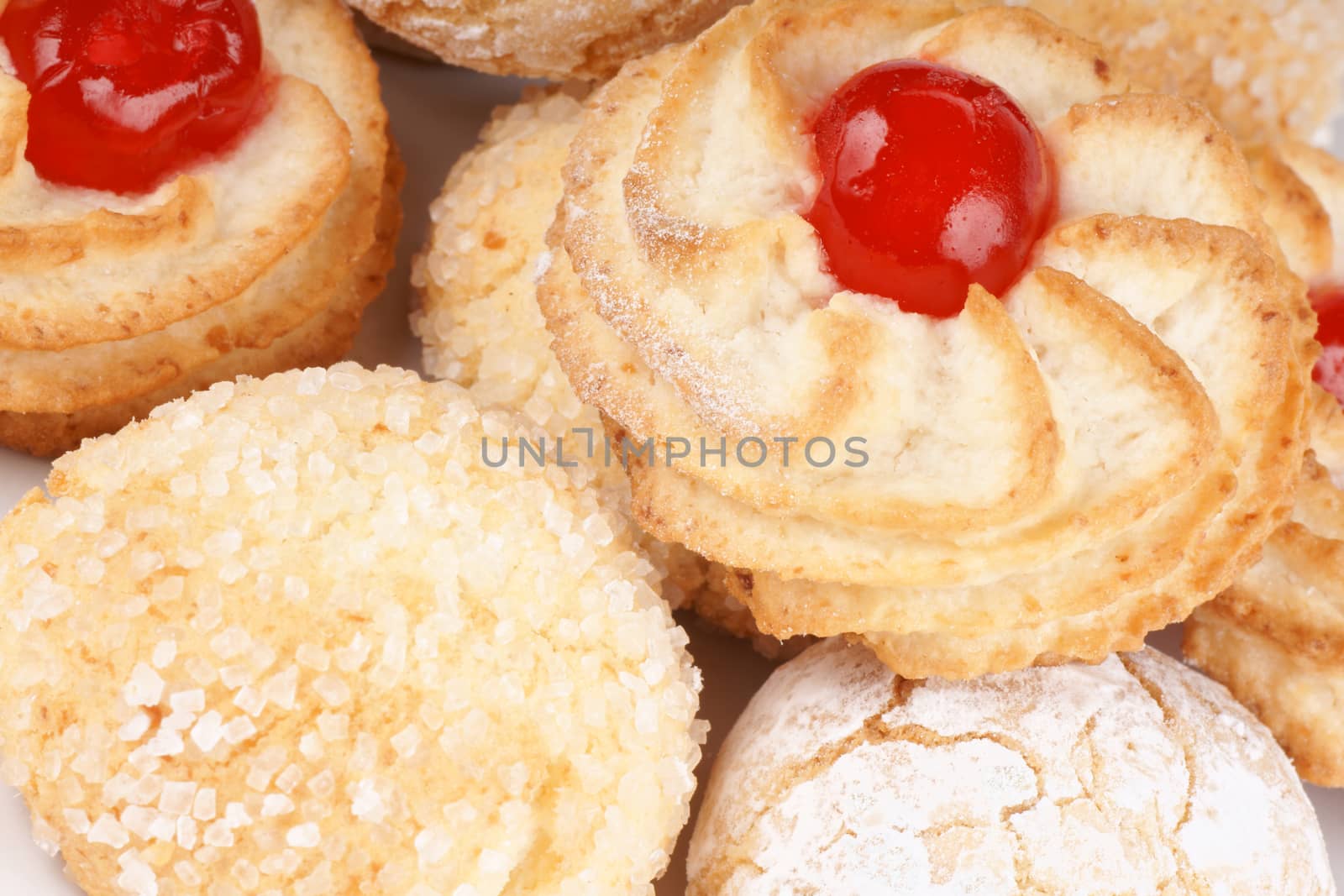 Close-up of assorted sicilian almond pastries decorated with candied cherries, icing sugar and granulated sugar. Selective focus.