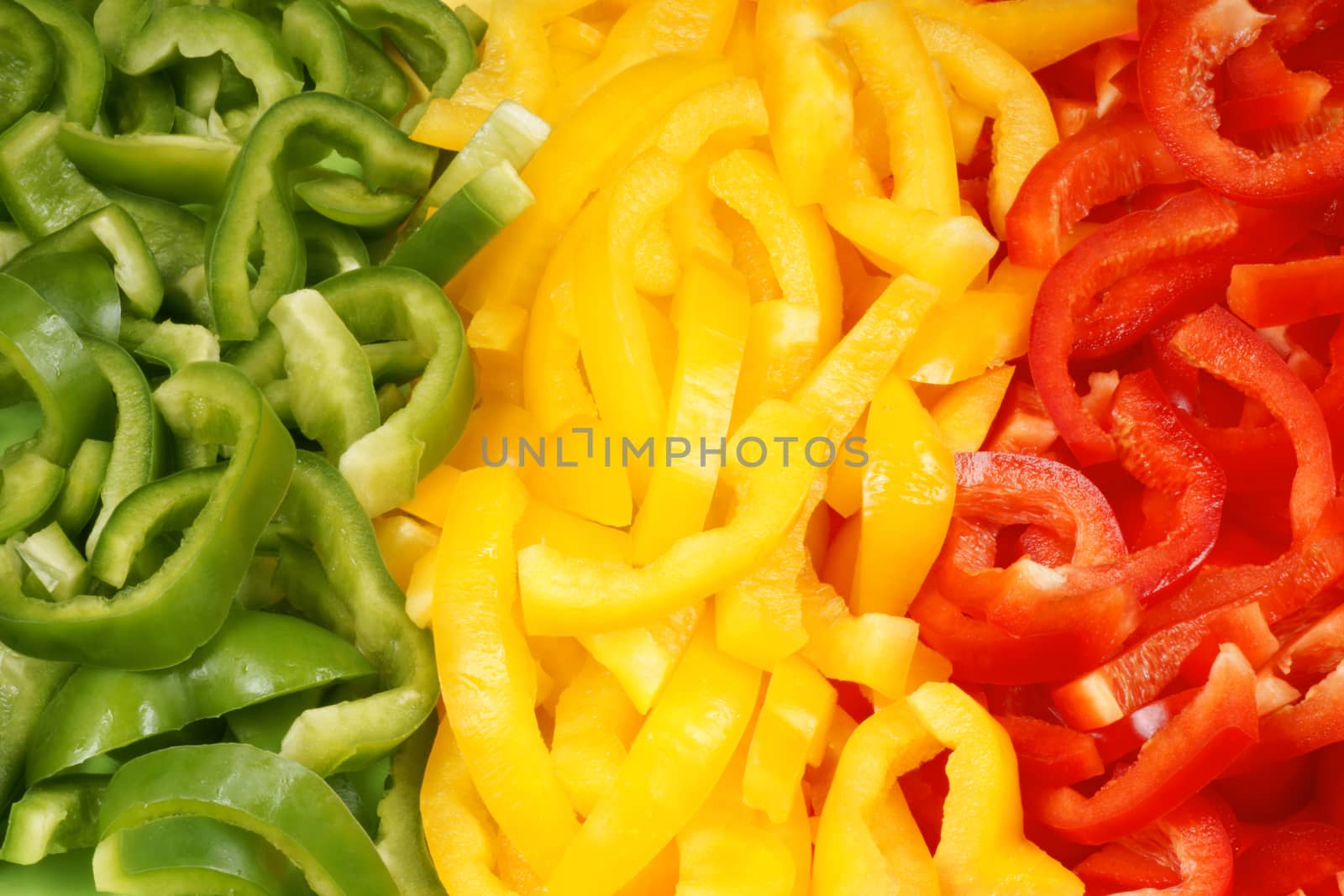 Organic background made of slices of green, yellow and red bell pepper. Organic flag of Mali.
