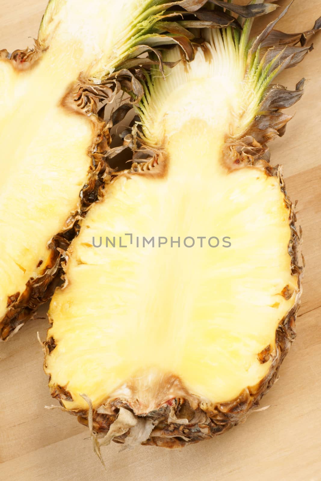 Fresh half cut pineapple over a wooden background.