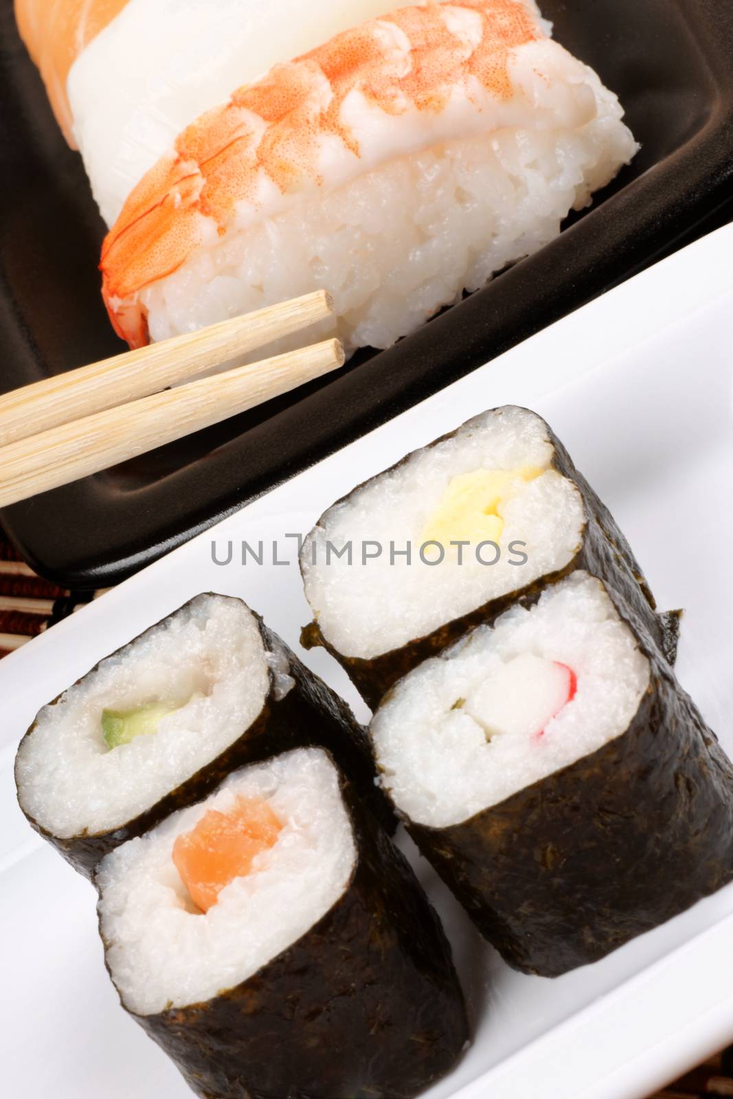 Close-up of sushi on a served on ceramic trays and wooden chopsticks. Selective focus. Shallow DOF