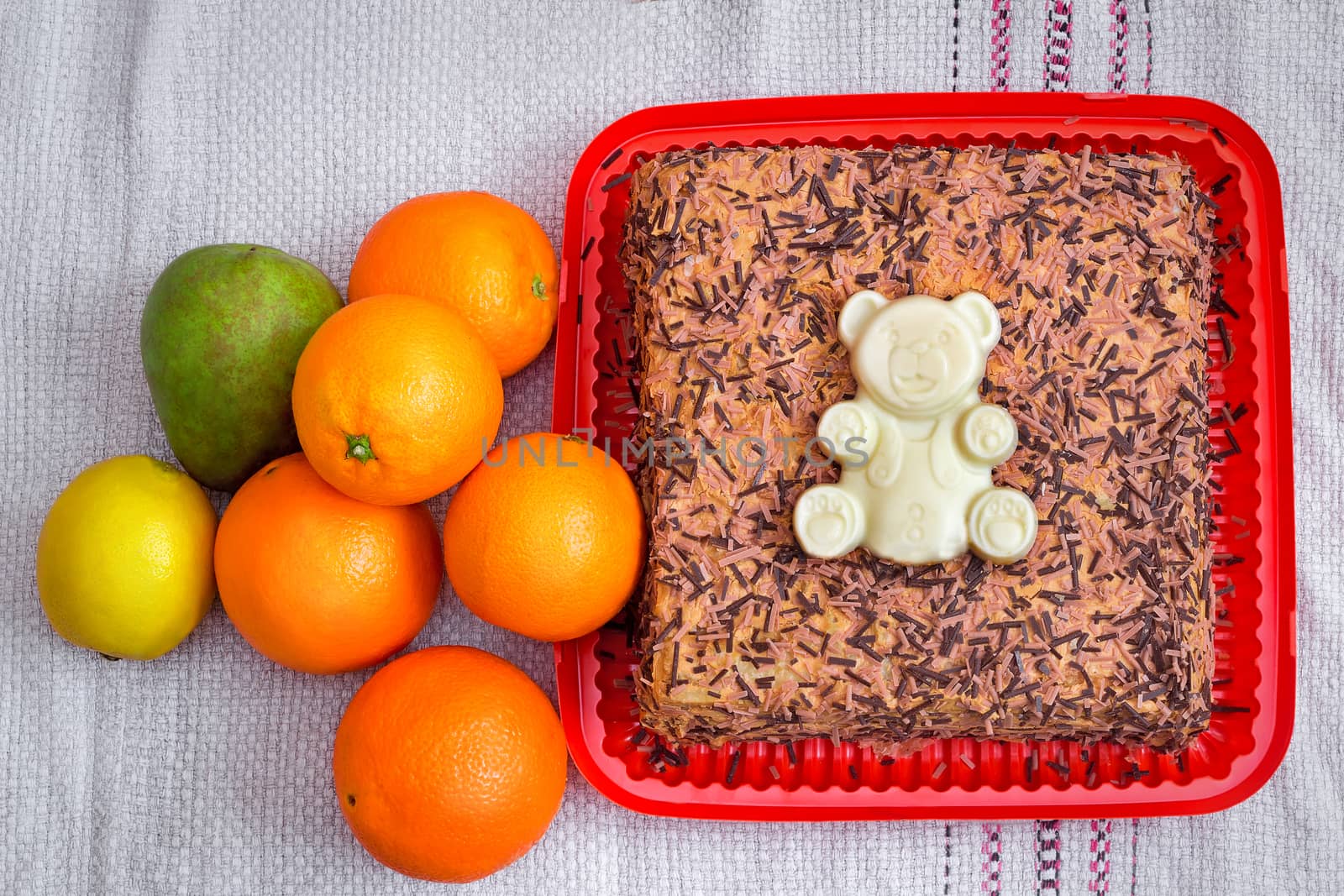 Delicious cake , decorated with the figure of a bear white chocolate, and fruit.