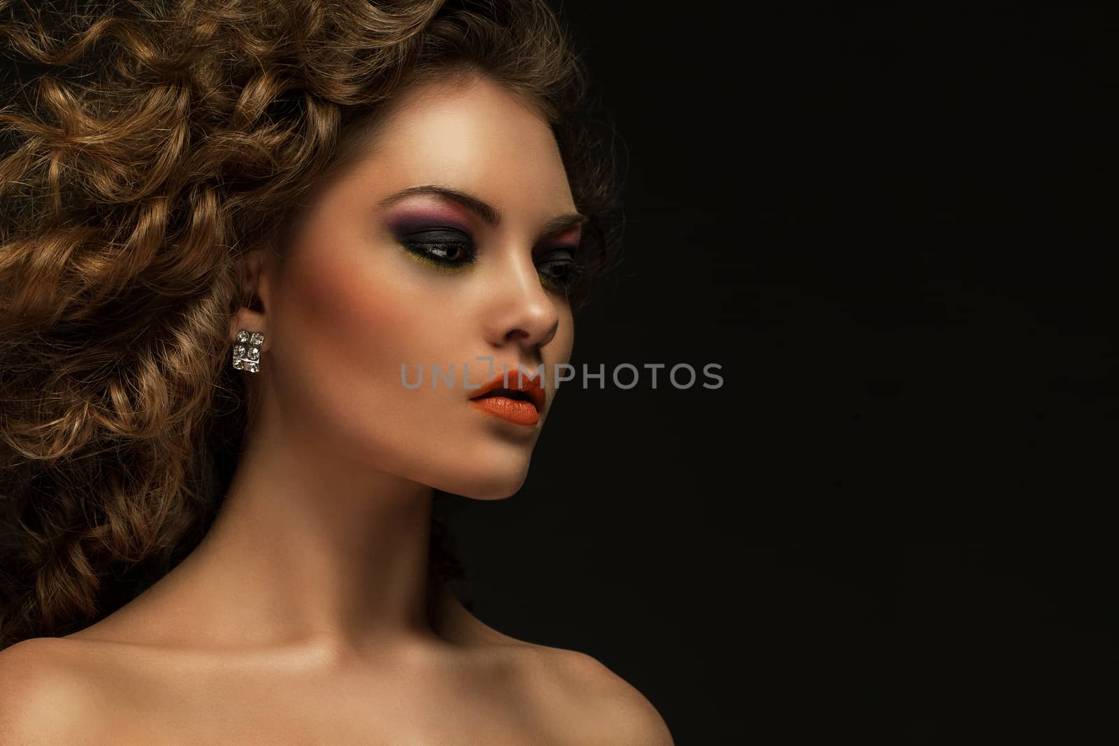 Beautiful caucasian woman with curls and evening makeup
