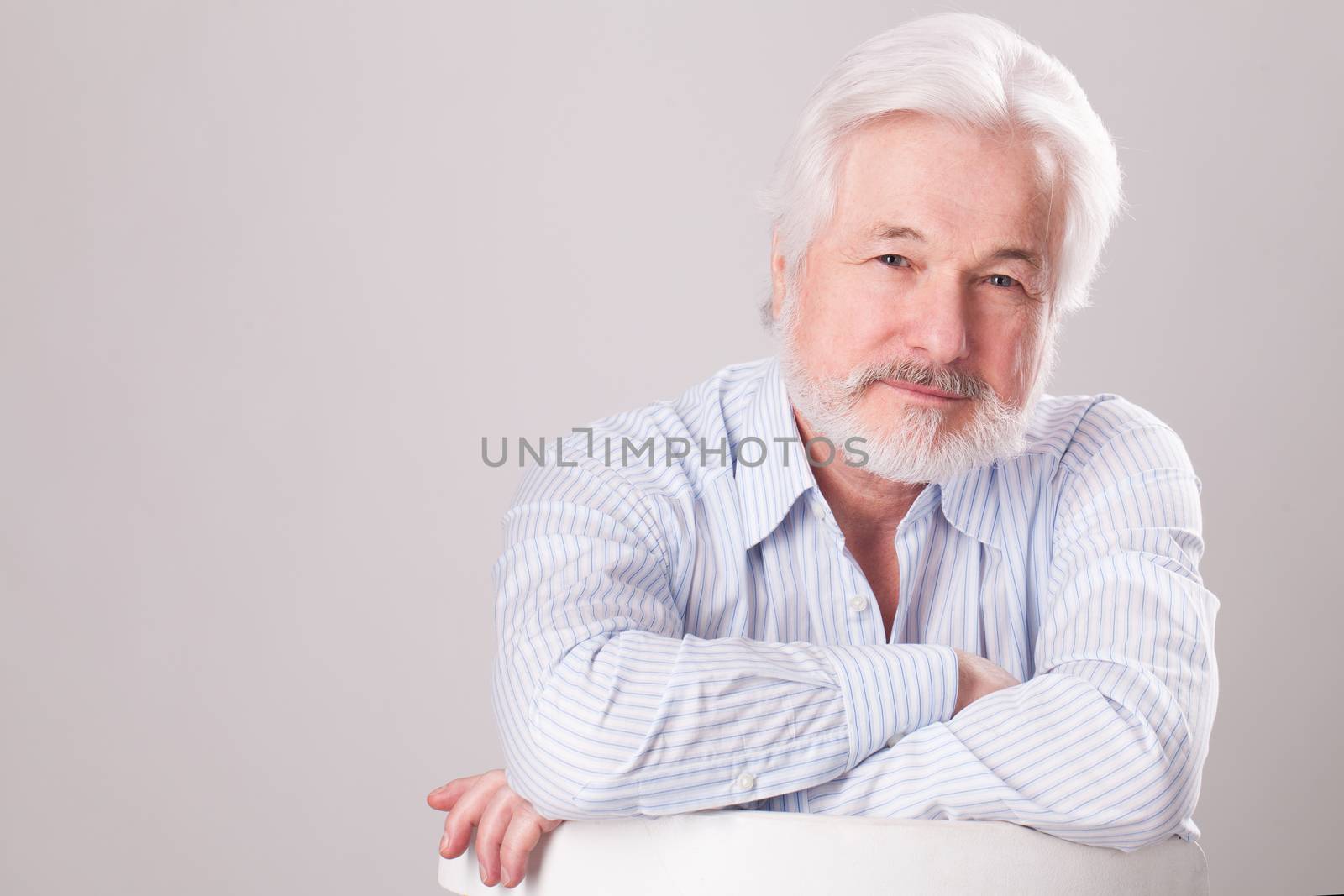 Handsome elderly man with grey beard over background