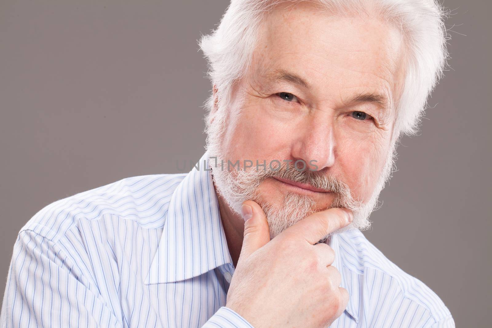 Handsome elderly man with grey beard over background