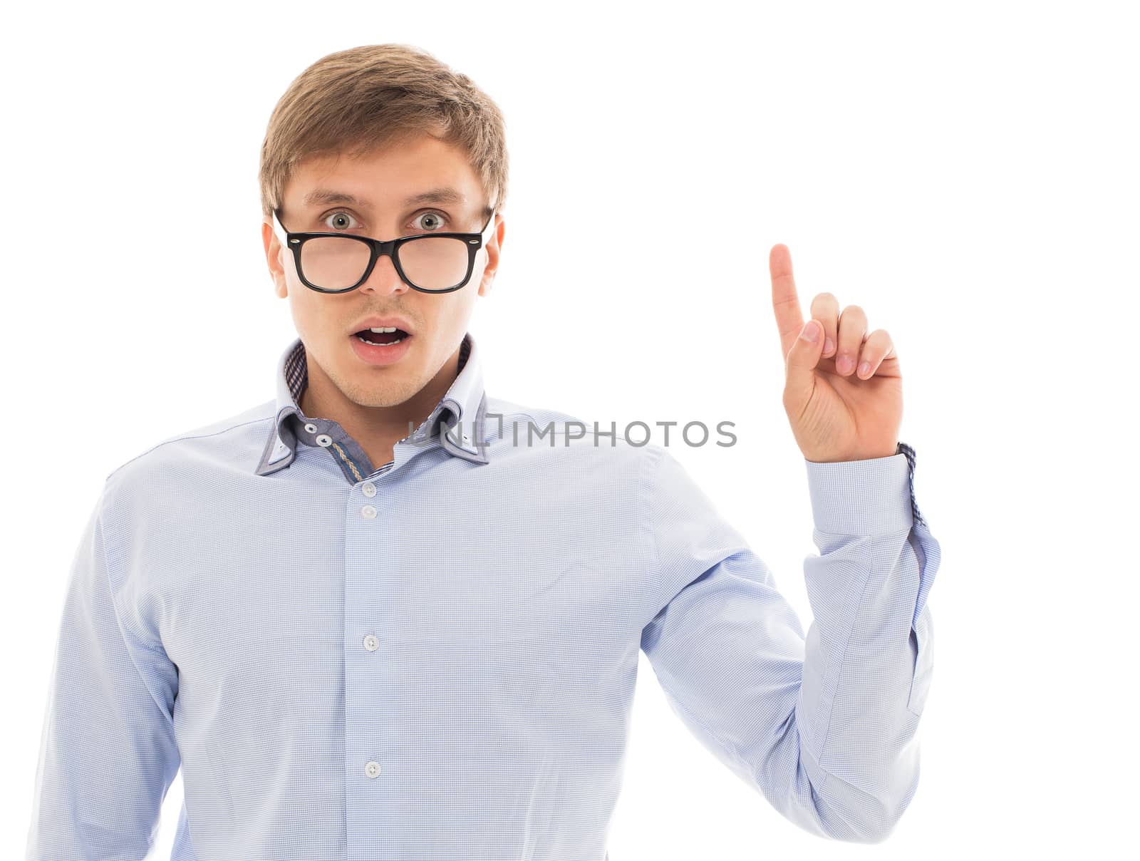Handsome man in a blue shirt and glasses points up over a white background