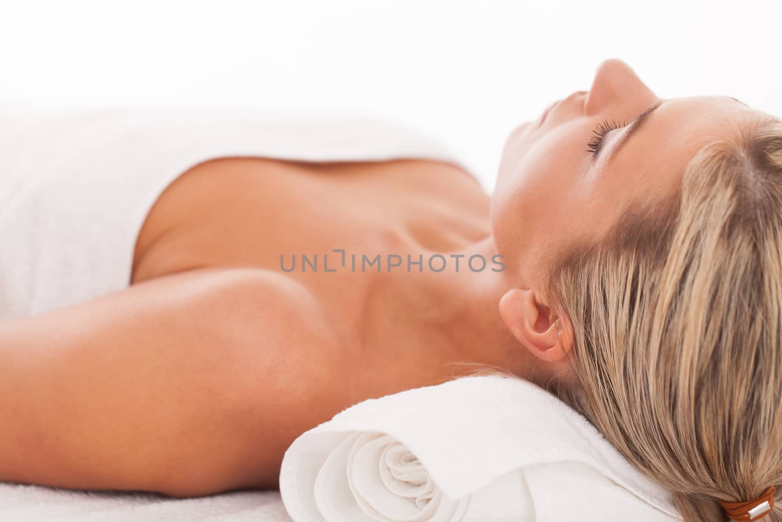 Beautiful caucasian woman with blond hair lying in a spa