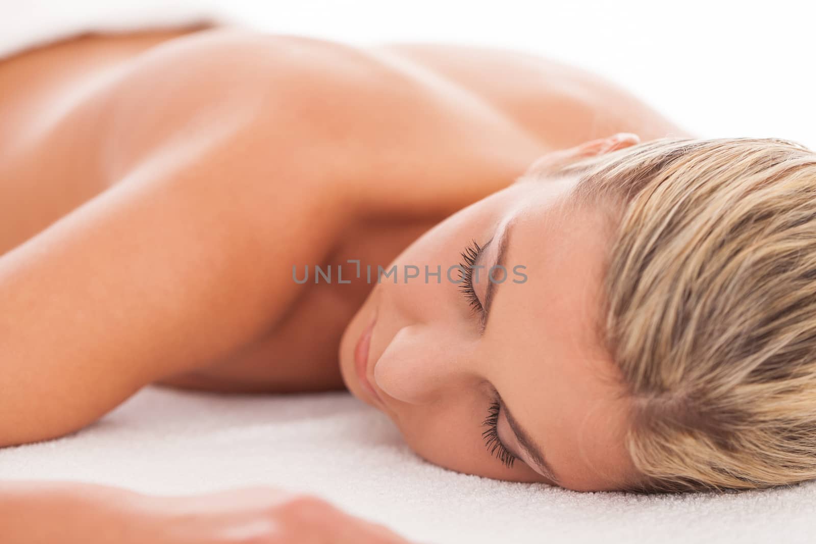 Beautiful caucasian woman with blond hair lying in a spa