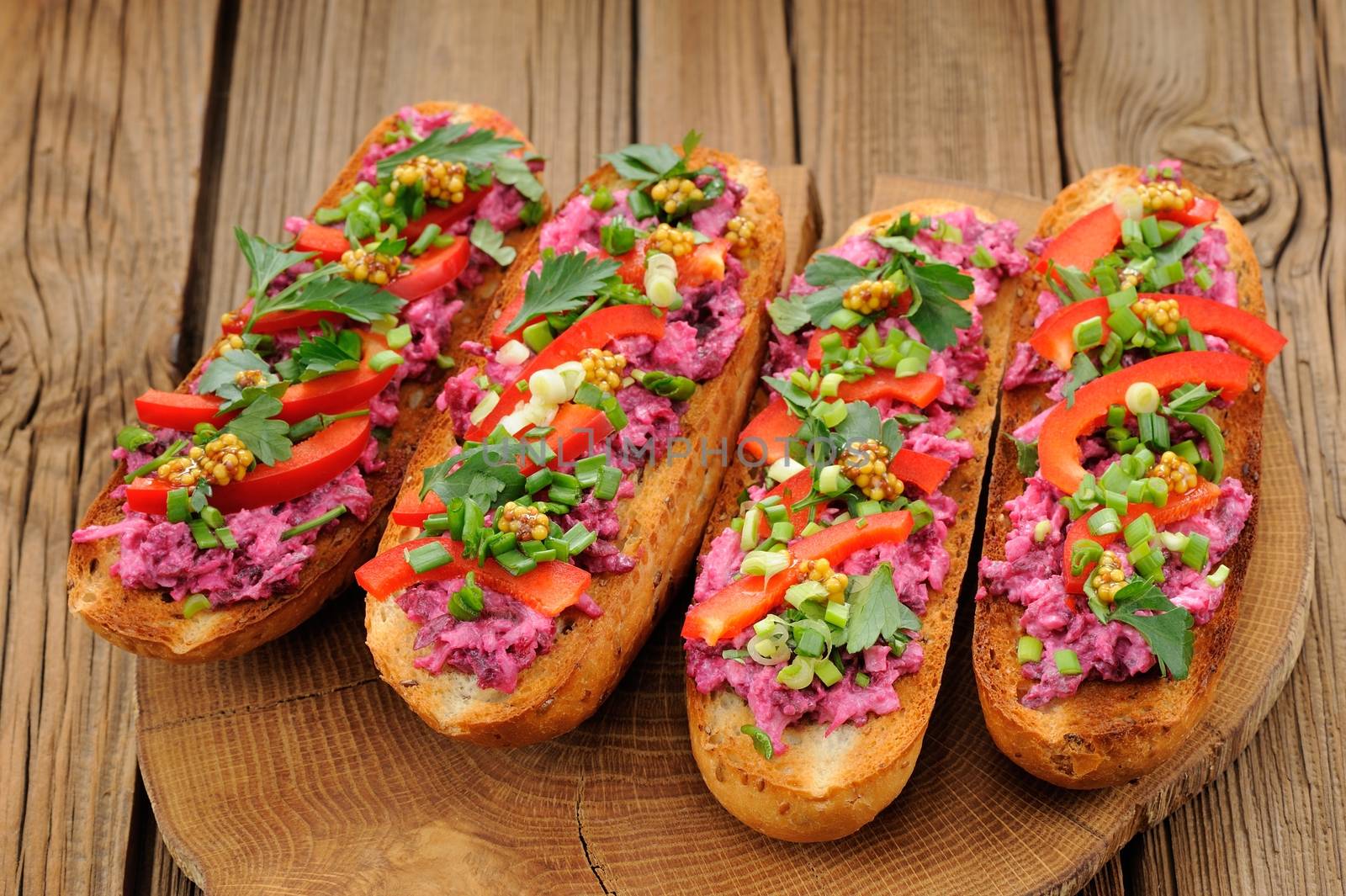 Vegetarian sandwiches with beetroot, bell pepper, parsley and scallion on wooden background horizontal