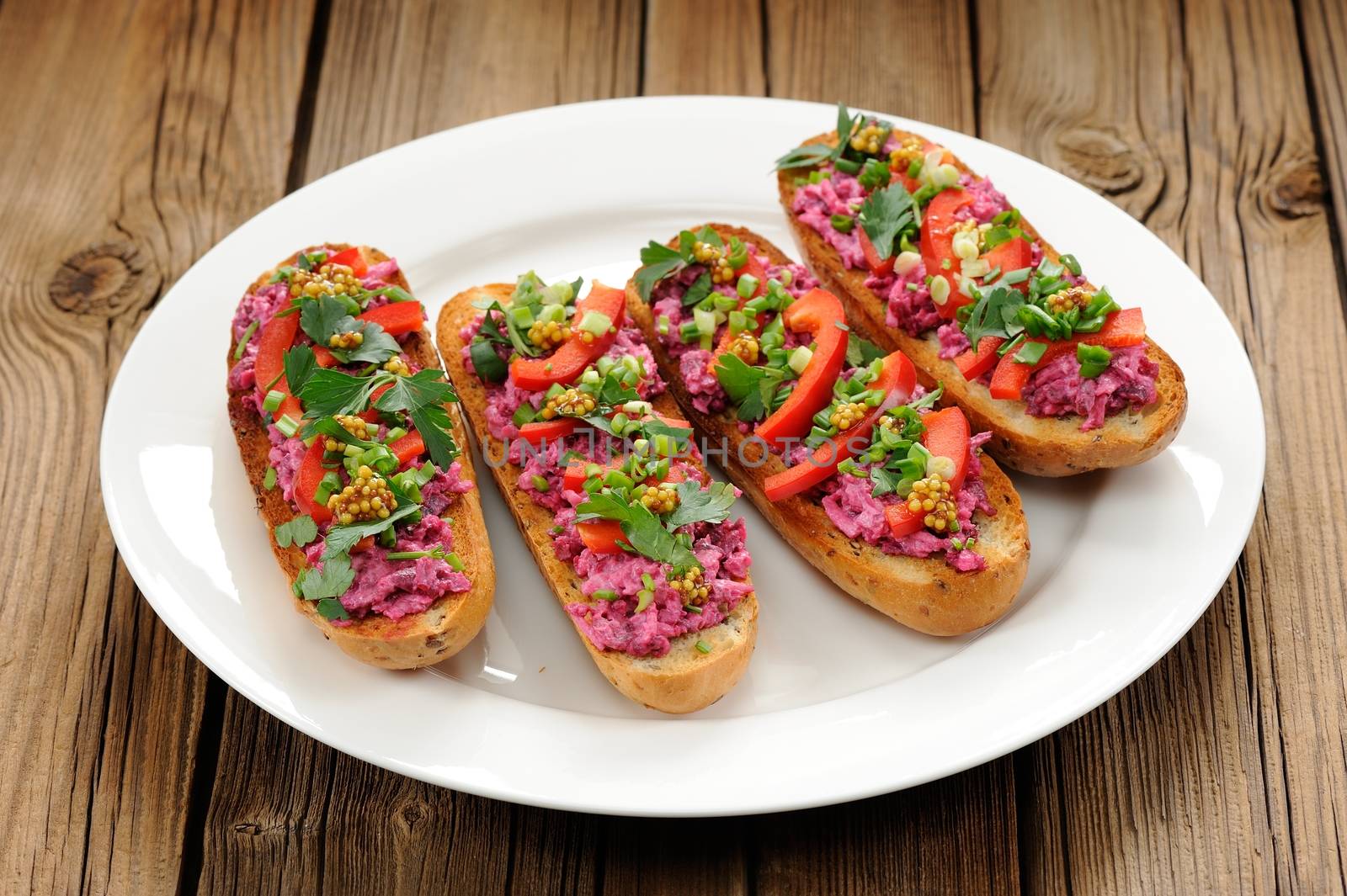 Vegetarian sandwiches with beetroot, bell pepper, parsley and scallion on white plate horizontal