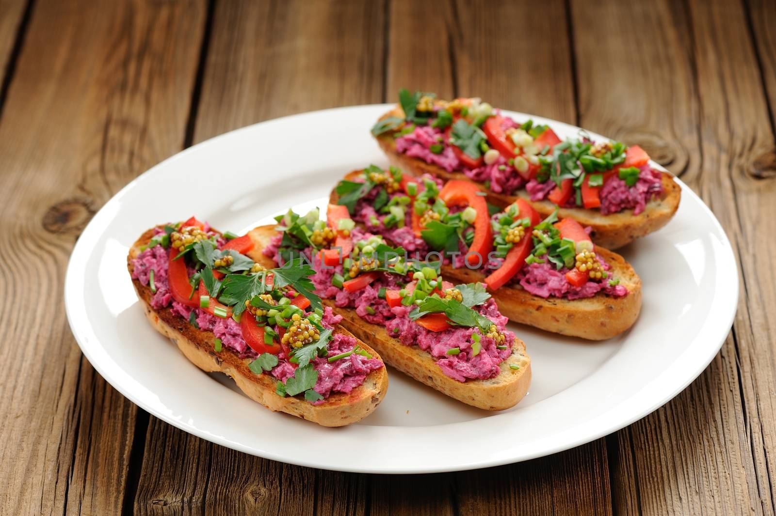 Vegetarian sandwiches with beetroot, bell pepper, parsley and scallion on white plate horizontal