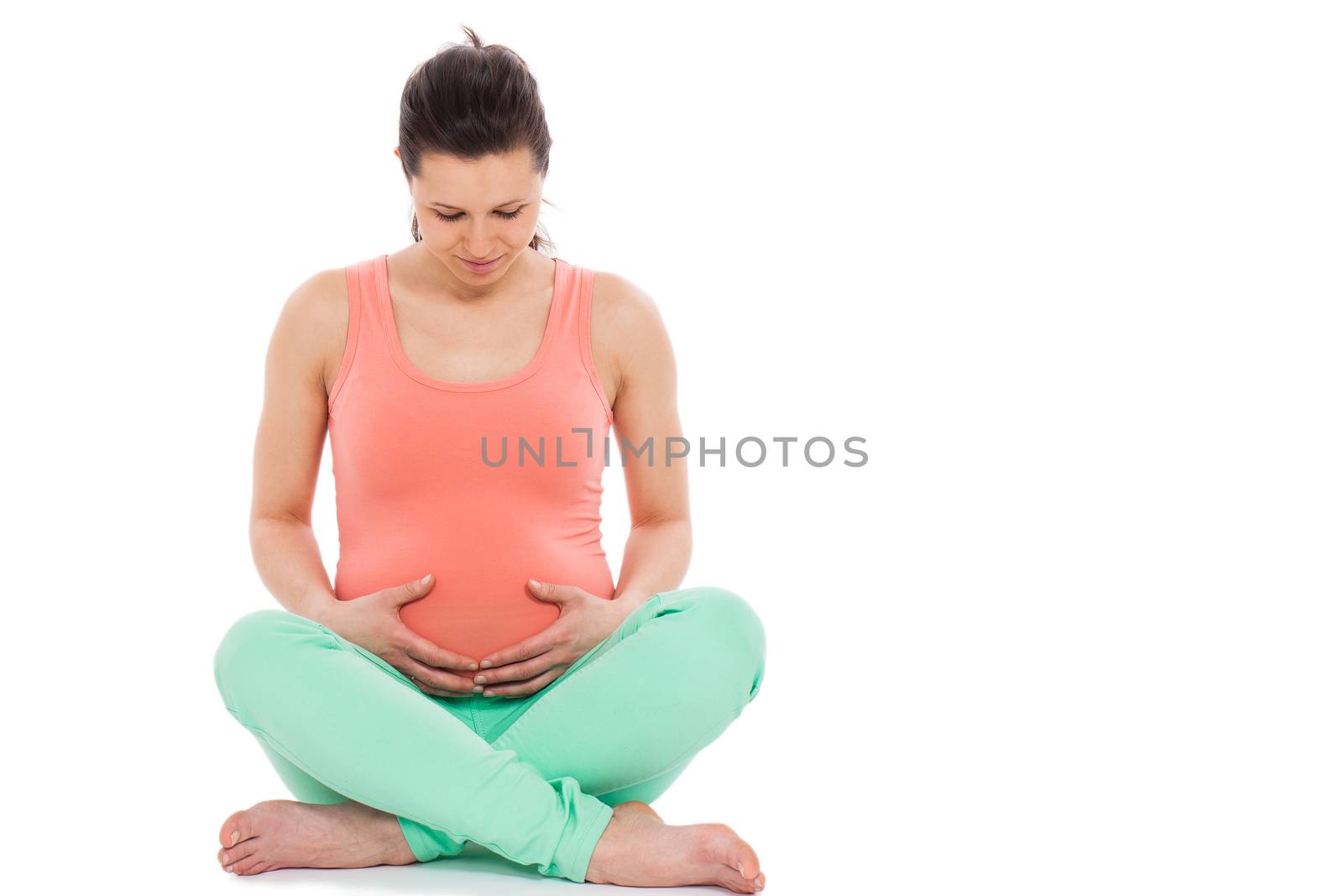 Beautiful pregnant woman sitting; isolated over white background