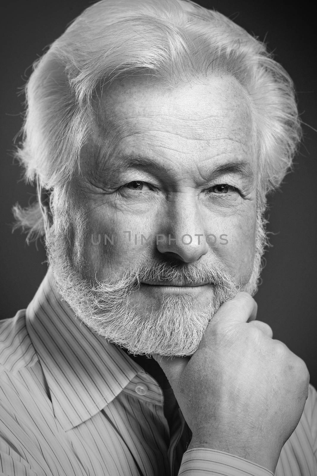 Closeup portrait of elderly man with beard on a black background