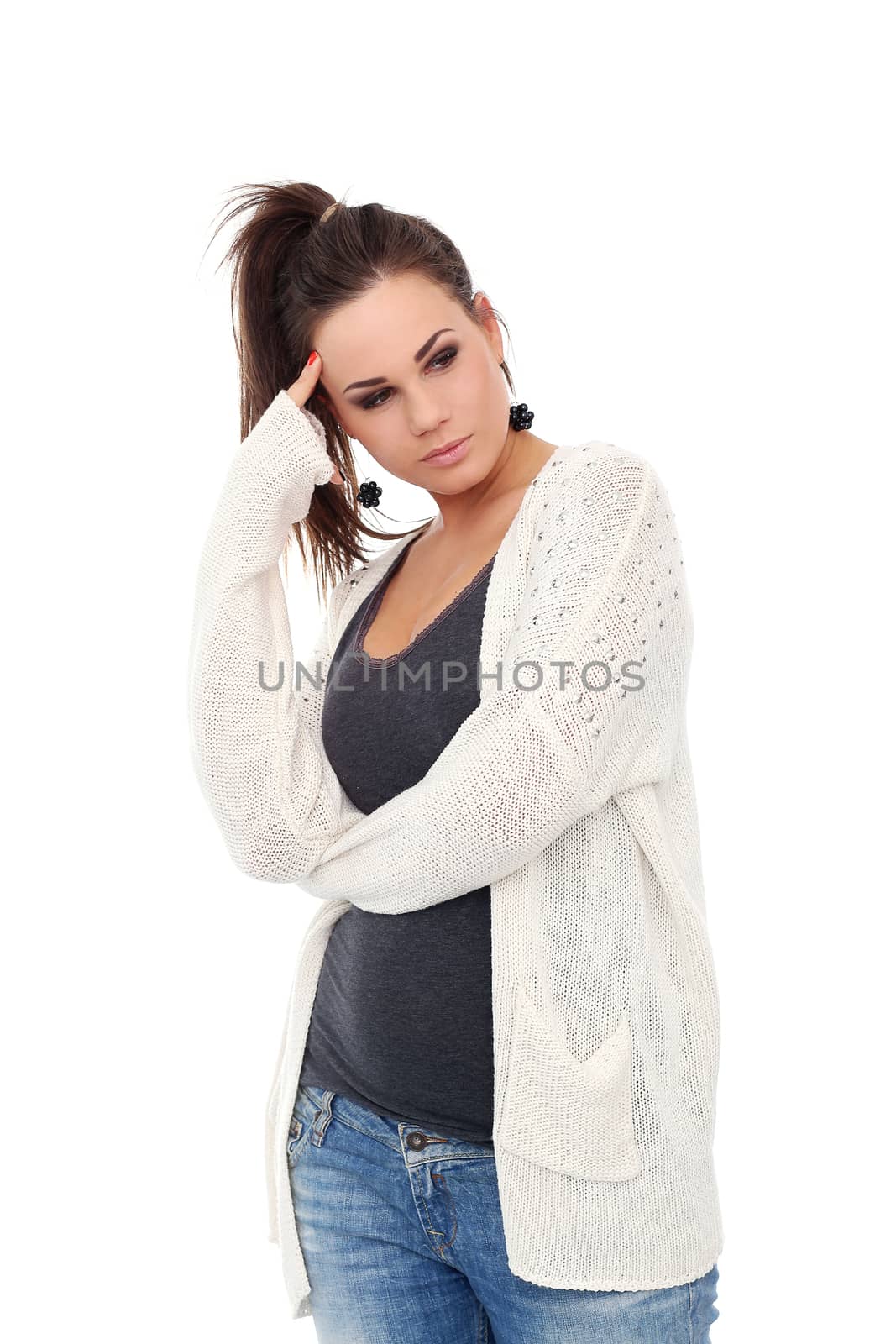 Portrait of a beautiful girl with brown hair who is posing in long white blouse over a white background