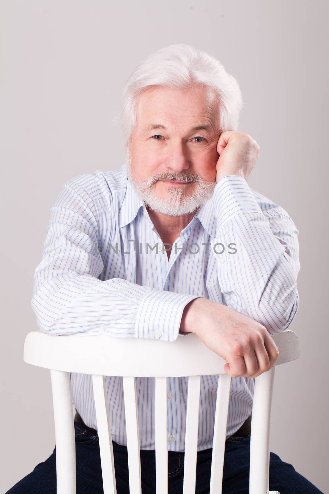 Handsome elderly man with grey beard over background