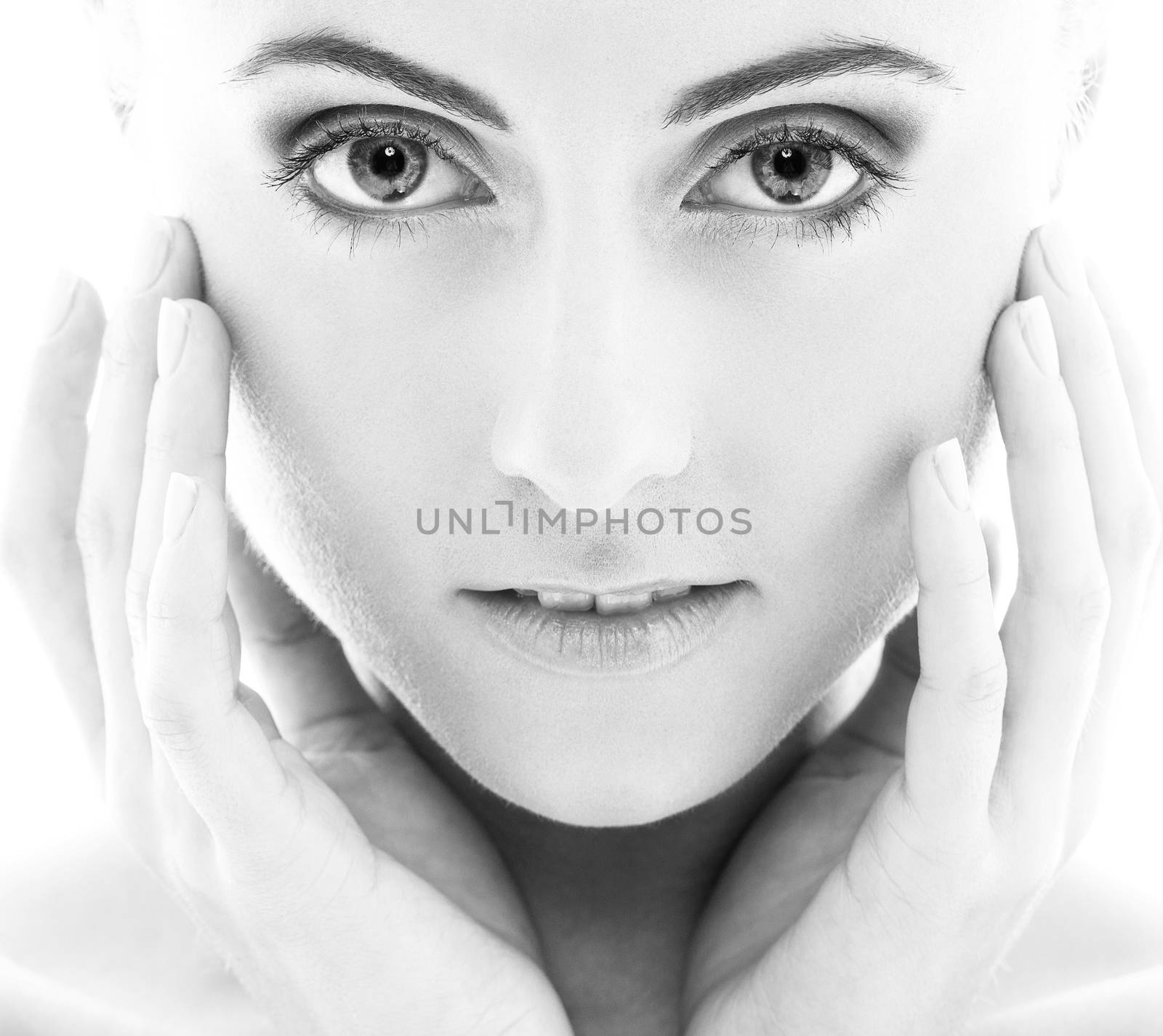 Black and white portrait of a beautiful girl with naked shoulders who is posing over a white background