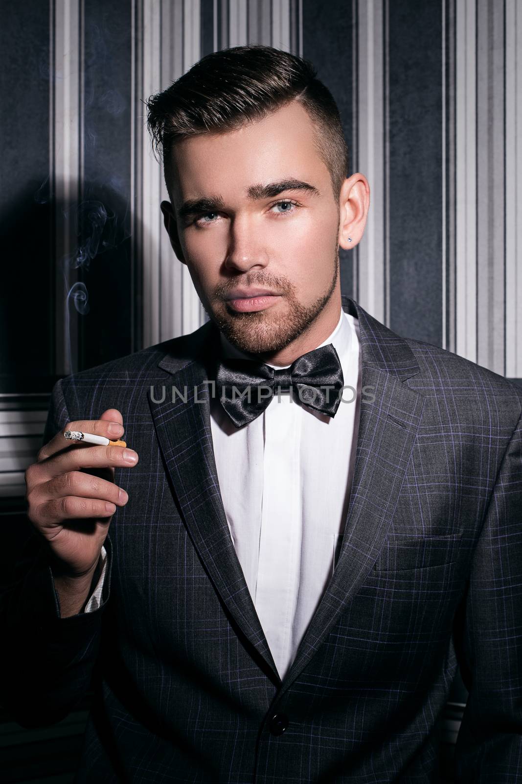 Portrait of a handsome man in a suit with a cigarette