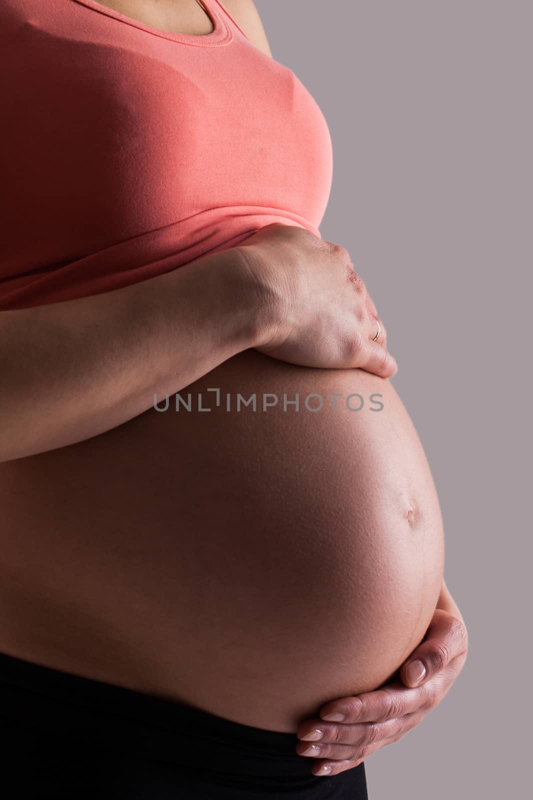 Beautiful pregnant belly on a grey background