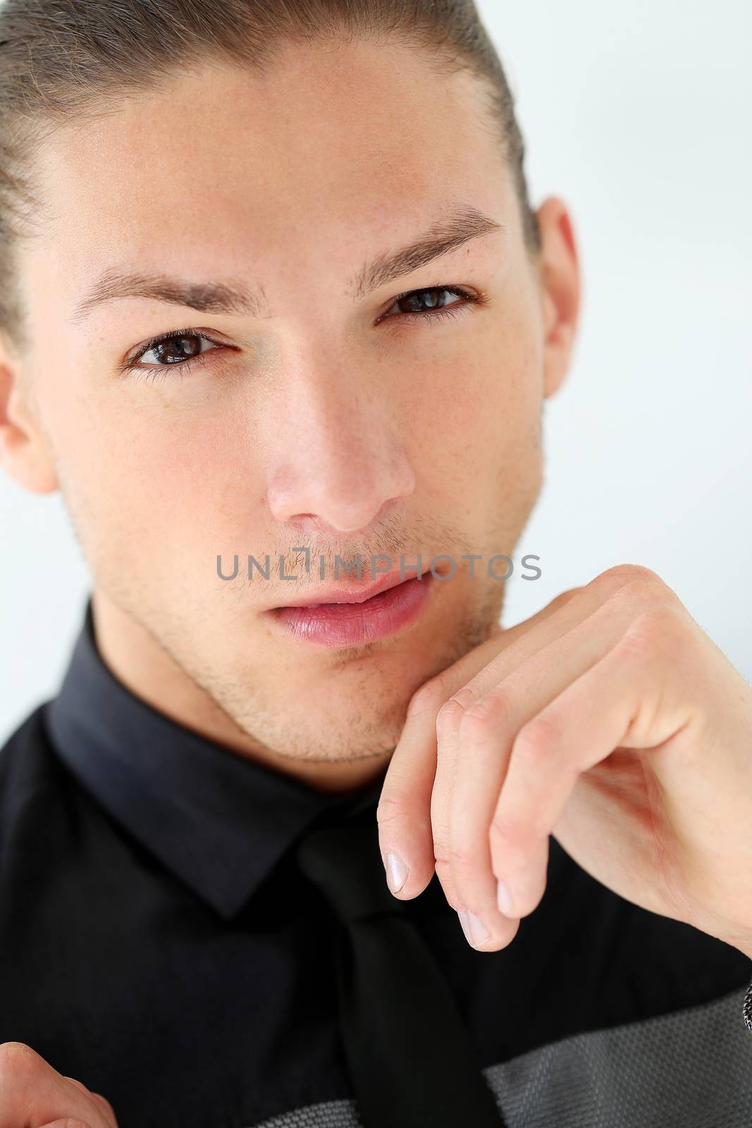 Portrait of a handsome man in a suit with a beard who is posing over a white background