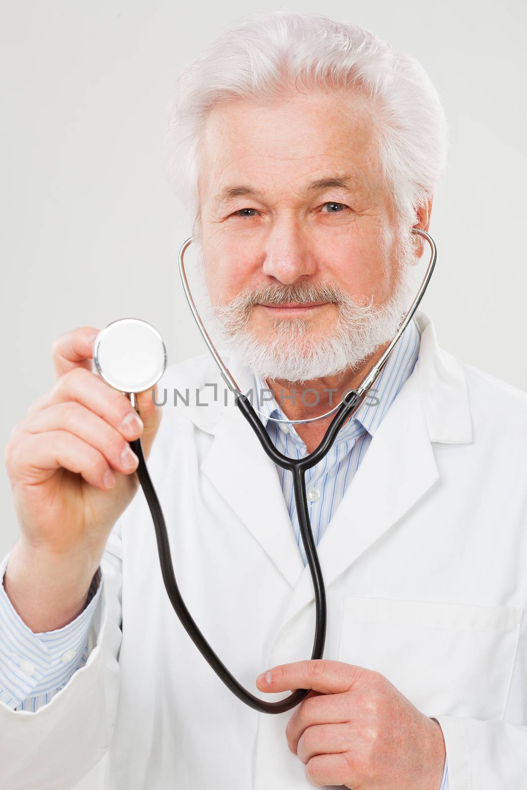 Handsome elderly doctor in uniform isolated over light background