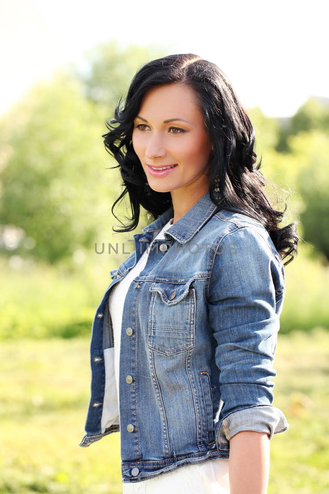 Beautiful young woman with jeans jacket in a park