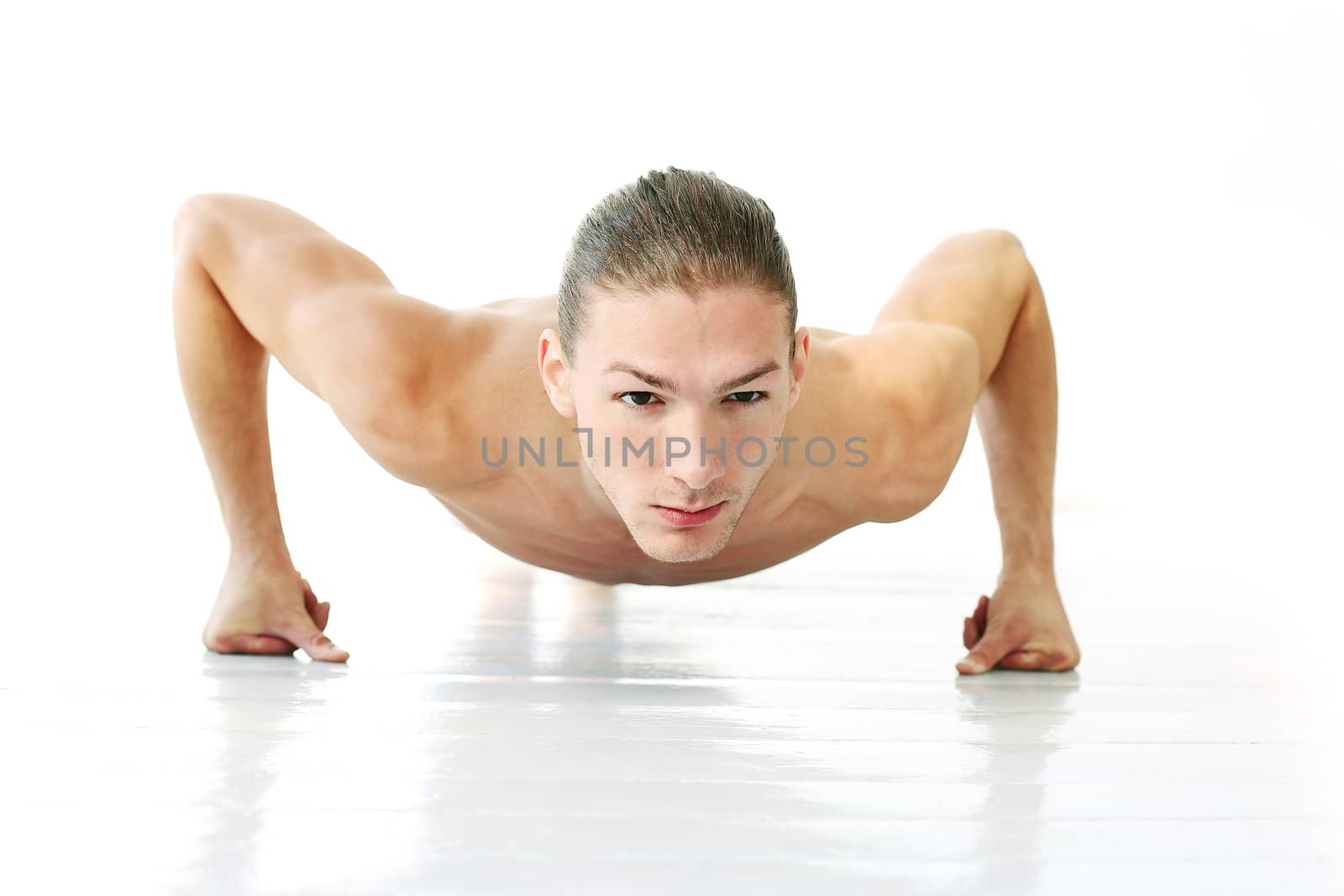 Portrait of a handsome shirtless man who is working out and posing over a white background