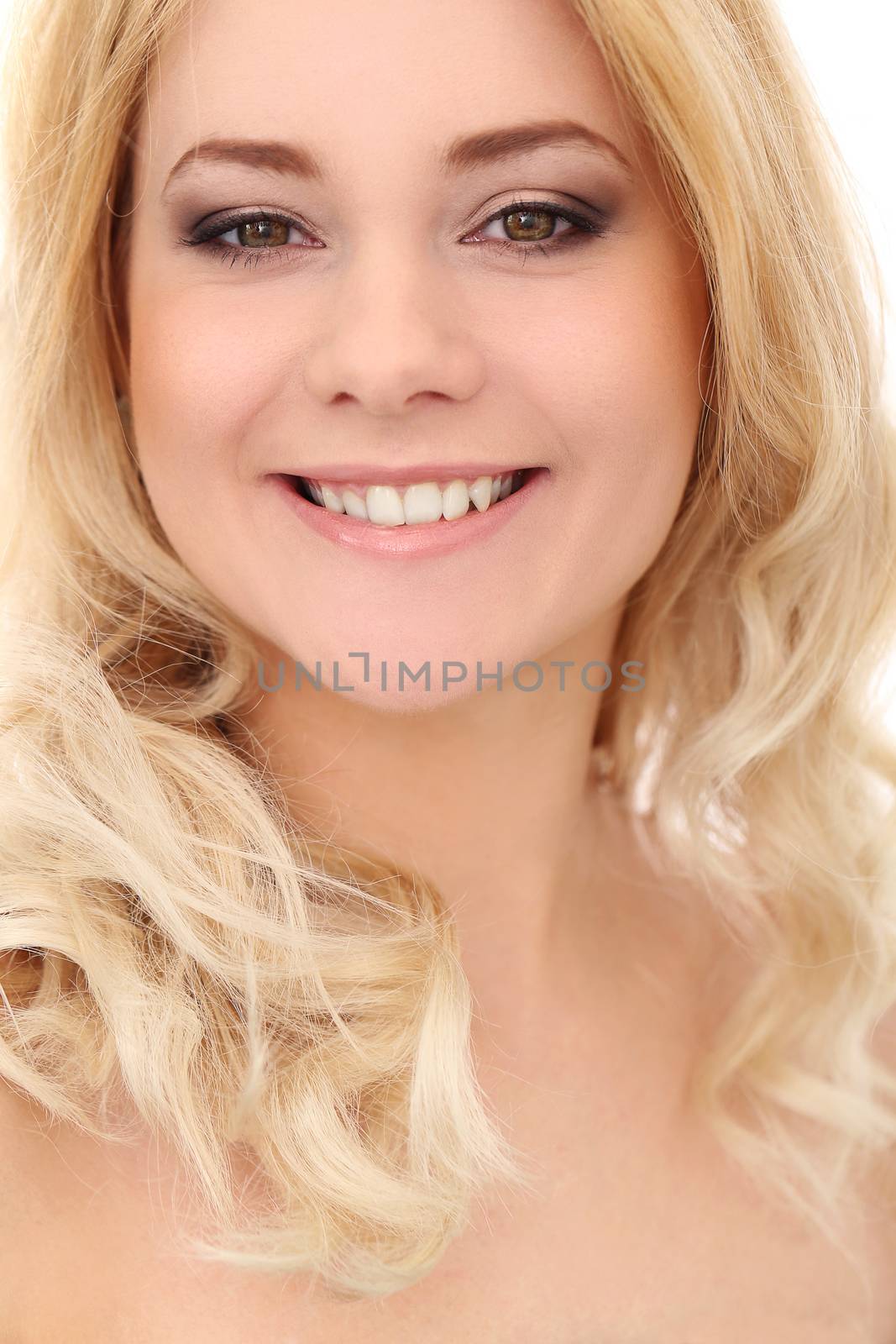 Portrait of a beautiful blonde girl with curly hair who is posing over a white background
