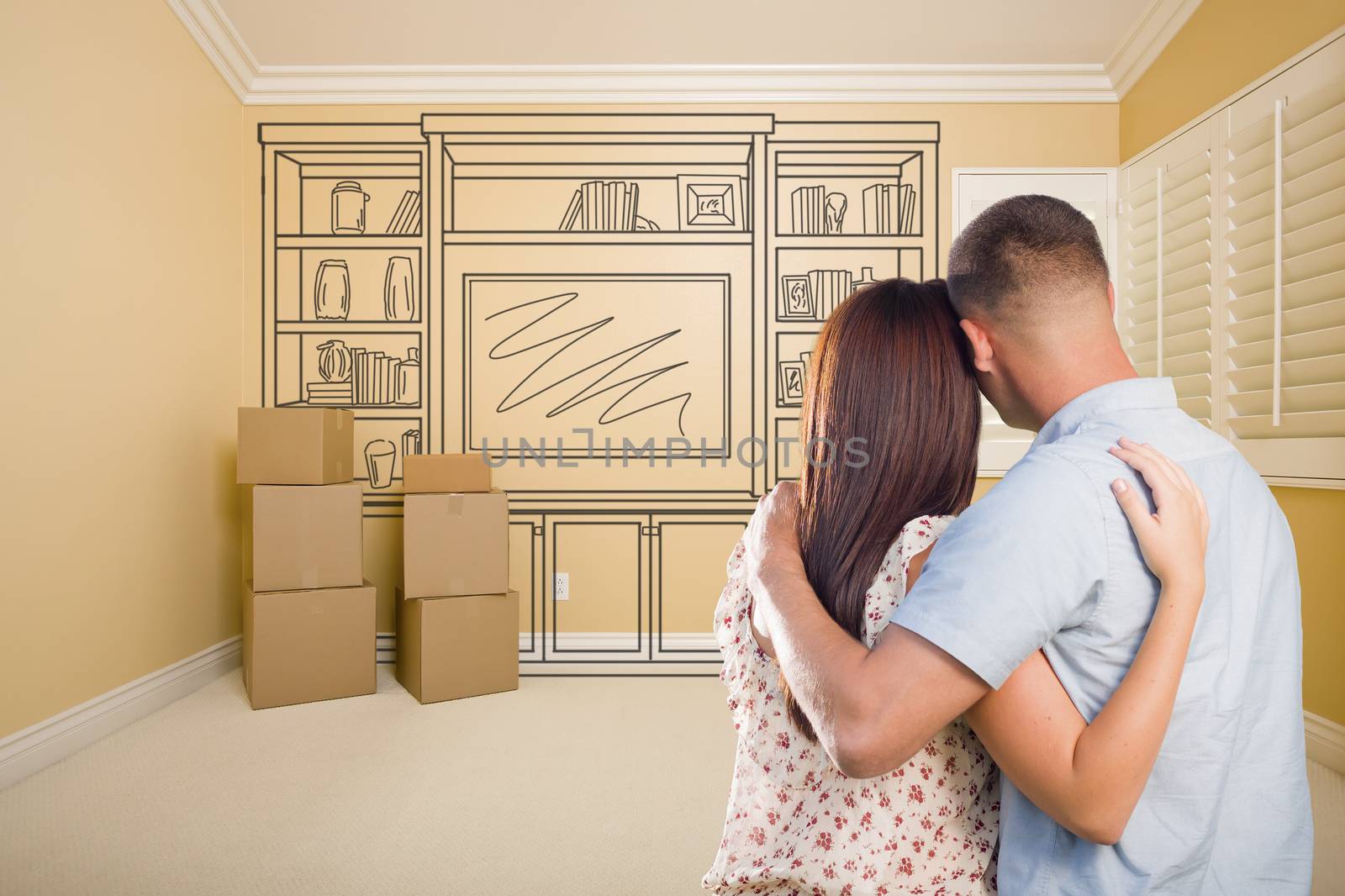 Hugging Military Couple In Empty Room with Shelf Design Drawing on Wall.