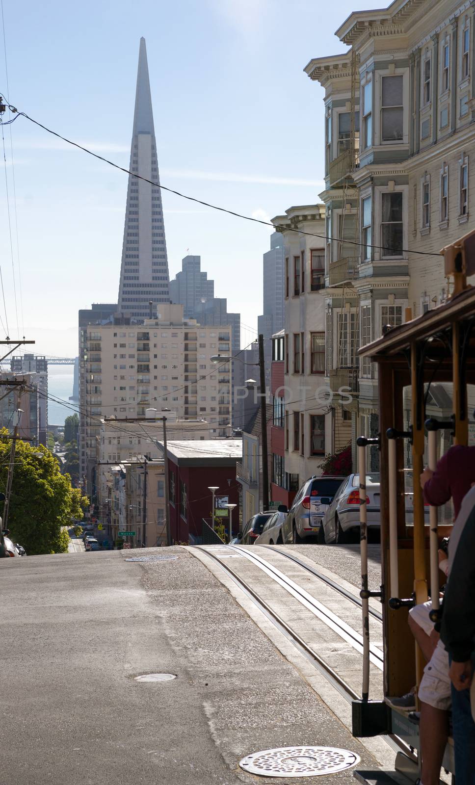 A San Francisco Trolly moves people along with Trans America Tower in the background