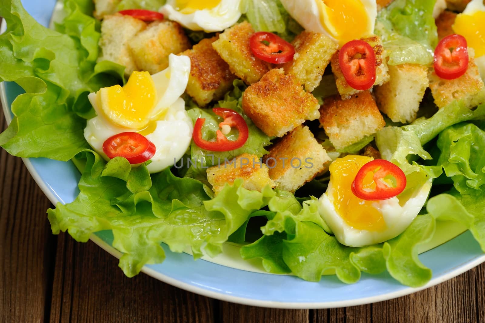 Salad Caesar with eggs, chili pepper closeup macro by Borodin