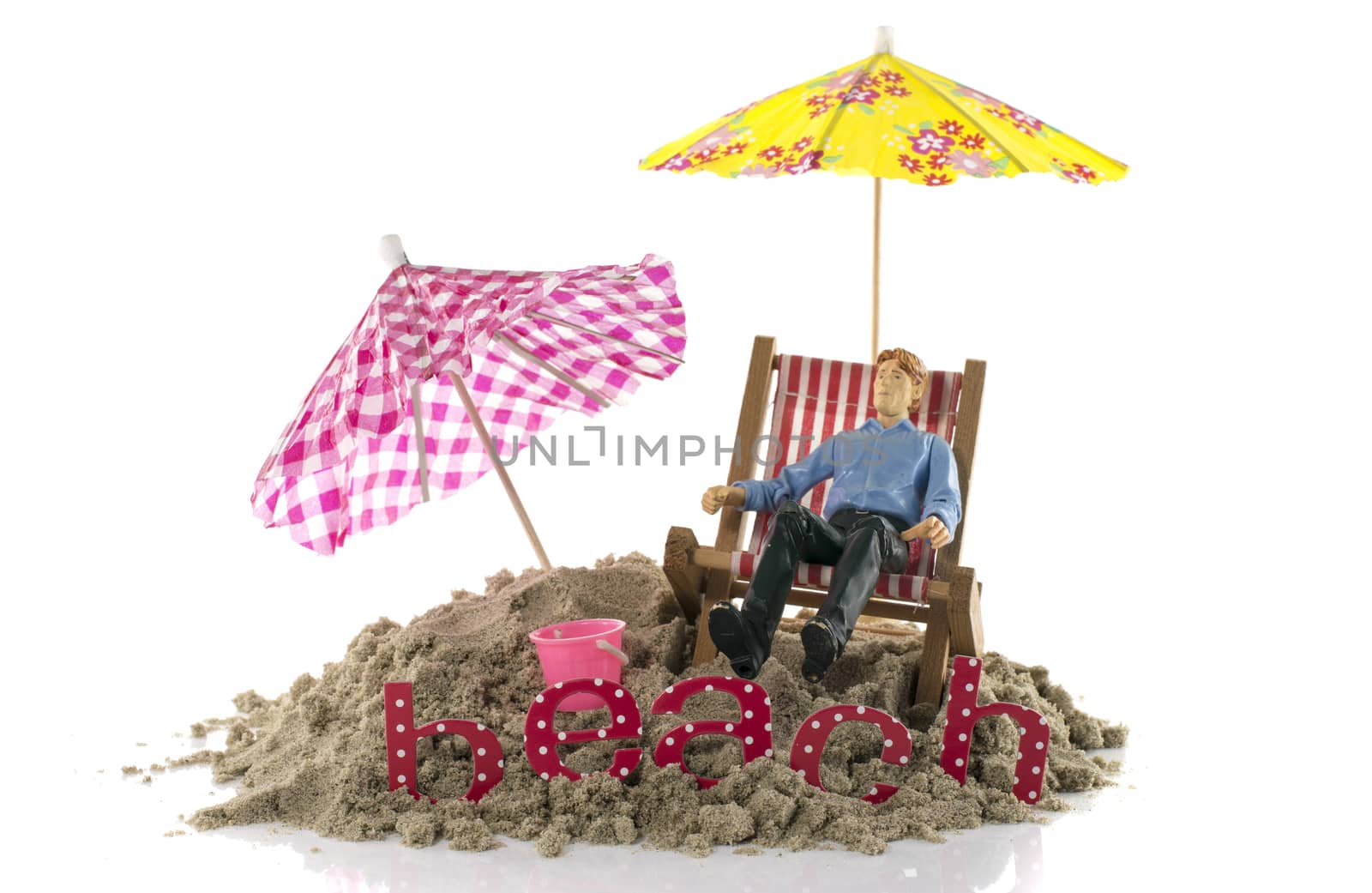 puppet toy man sitting in chair on the beach by compuinfoto