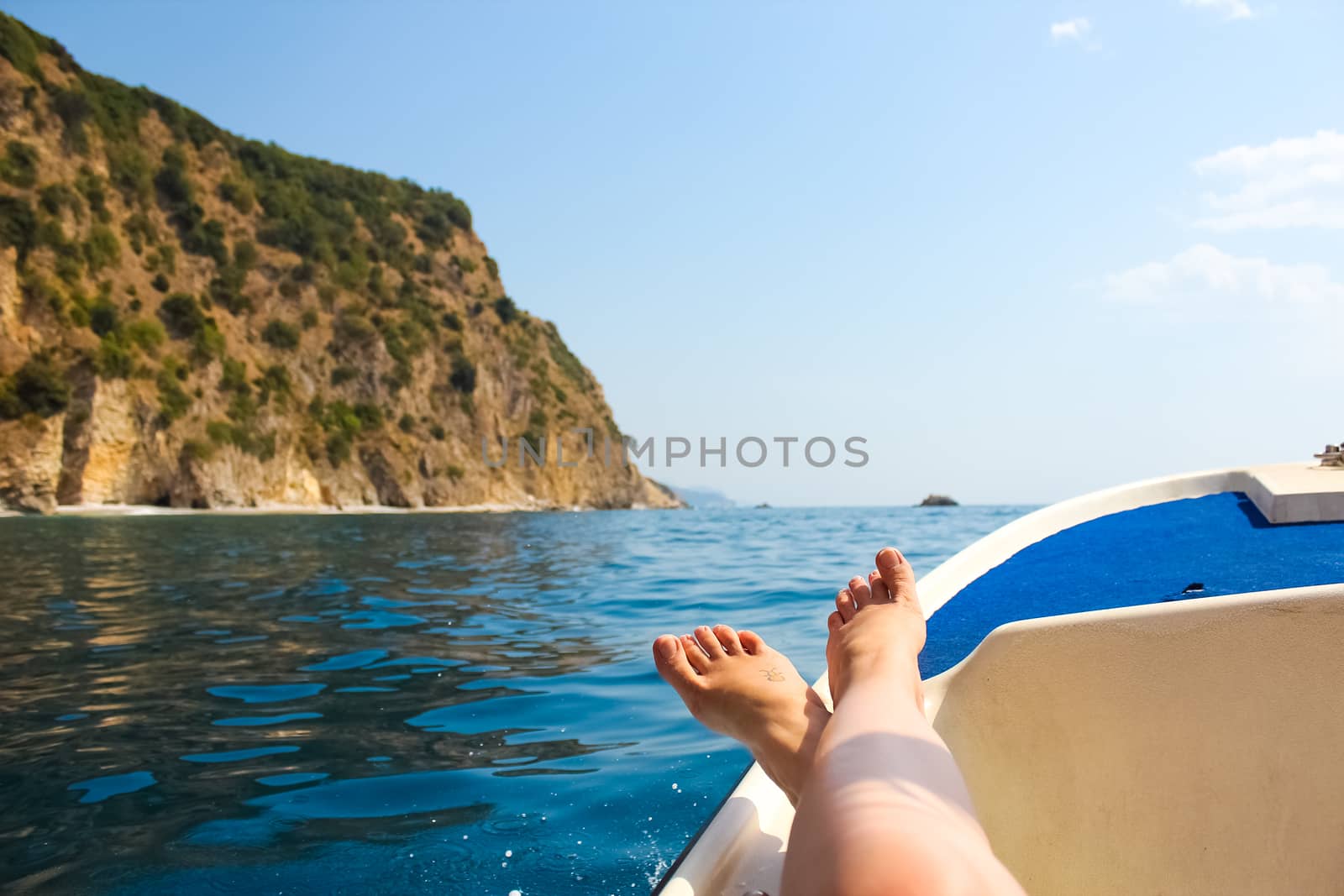 woman lounging on a catamaran sailboat by sarymsakov