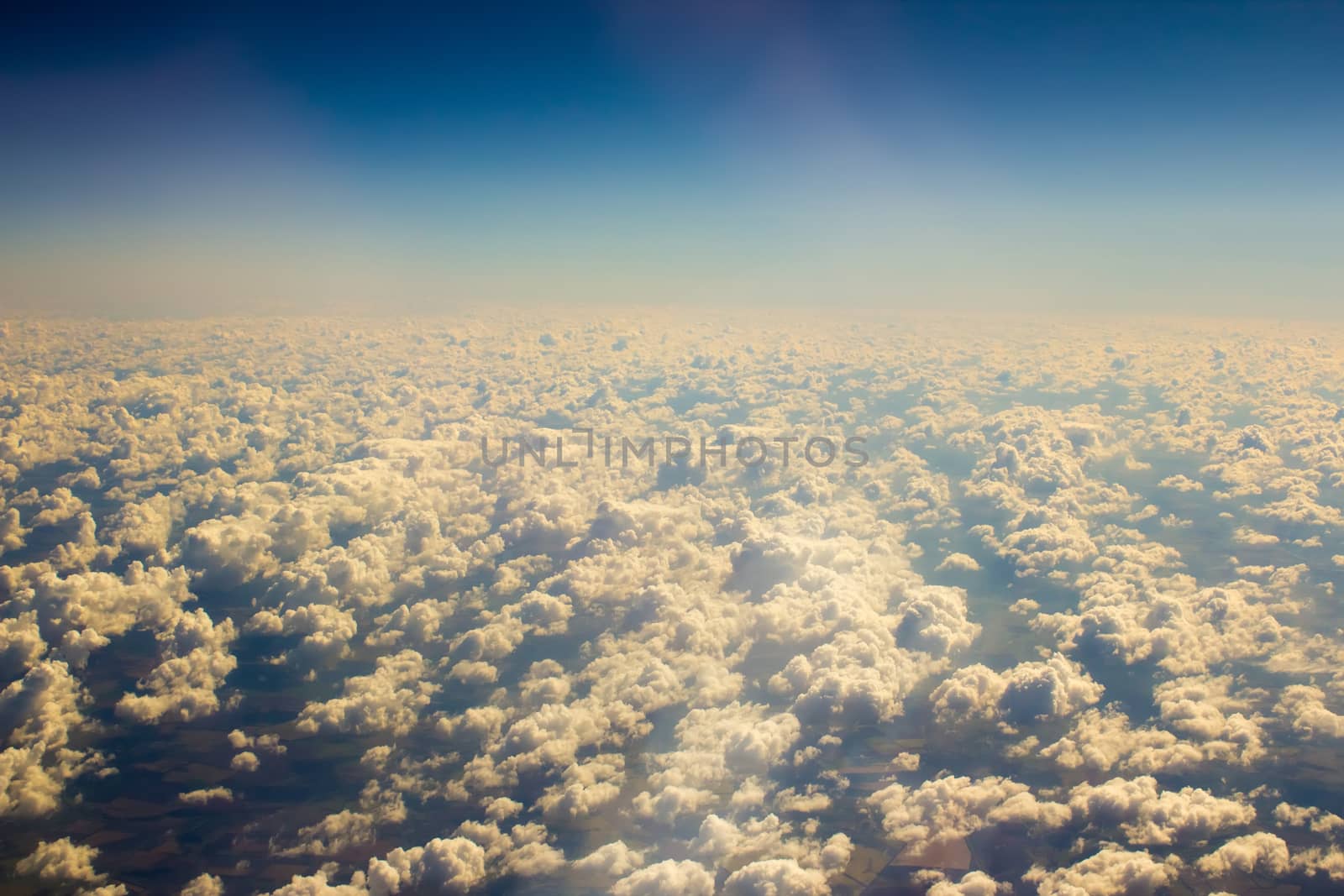 White clouds in a blue sky. Aerial view from airplane.