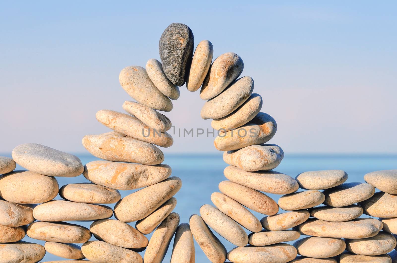 Arch of pebbles between of the stones on the seashore