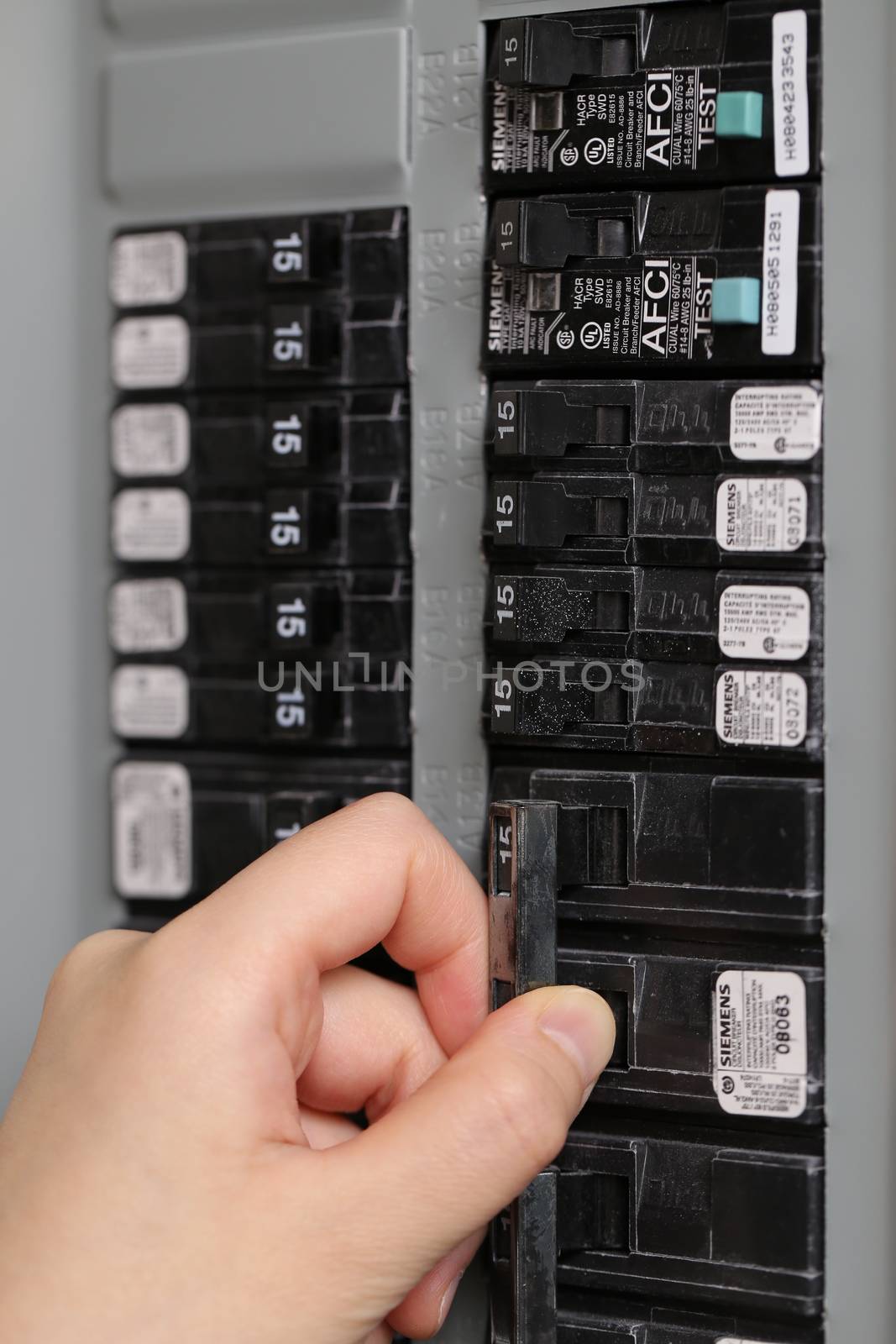 Coquitlam, BC, Canada - June 15, 2014 : Macro woman turning off the light-switch in the hall at home. 