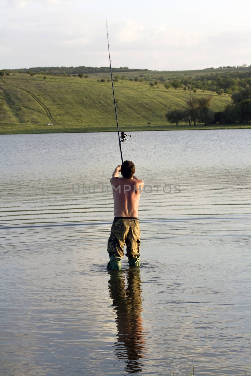 A man throws a fishing rod in the lake