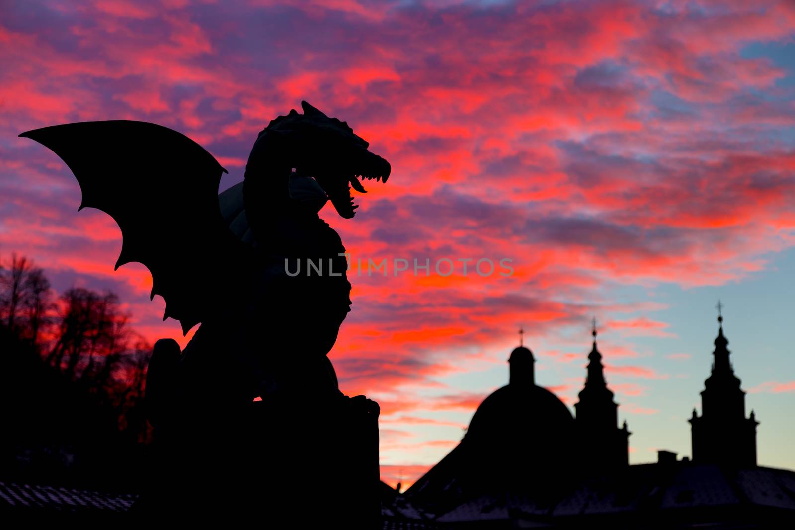 Vivid sunset sky over silhouette of Famous Dragon bridge, symbol of Ljubljana, capital of Slovenia, Europe.