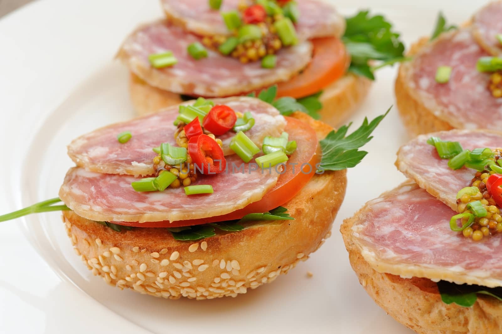 Ham sandwiches with chili, parsley and scallion on white plate c by Borodin