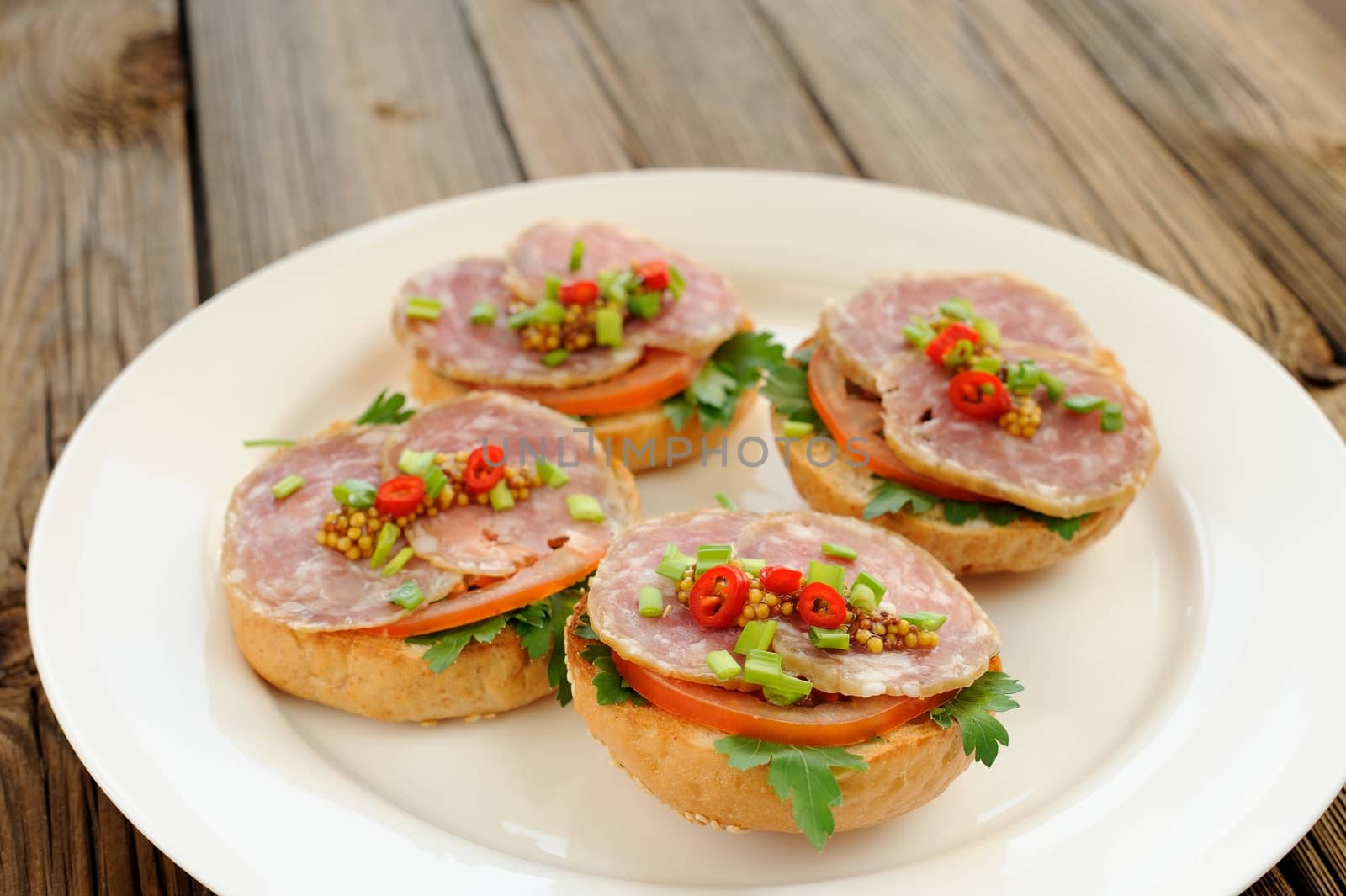 Ham sandwiches with chili, parsley and scallion on white plate by Borodin