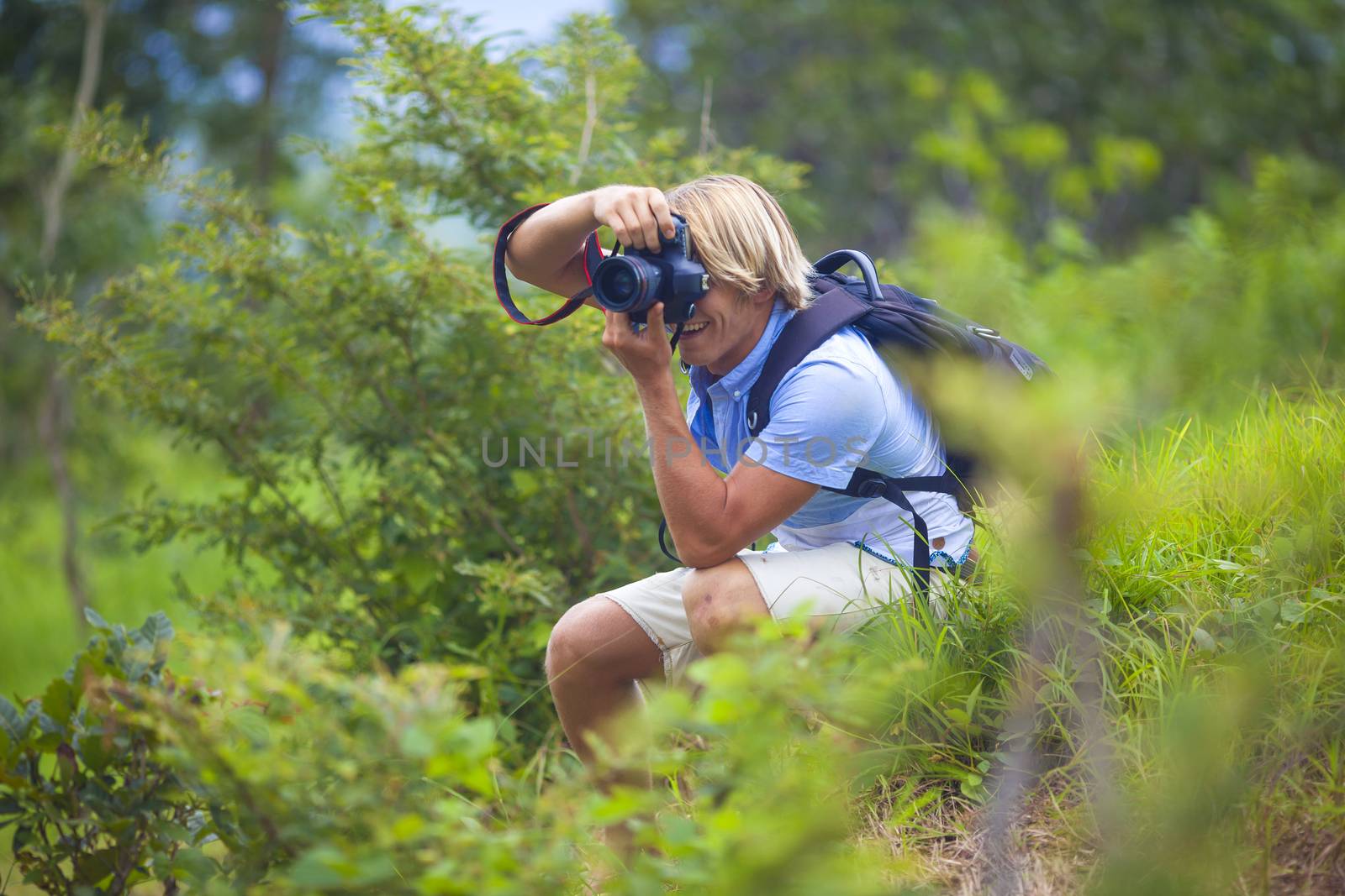 Photographer with Professional Digital Camera Taking Pictures in Nature