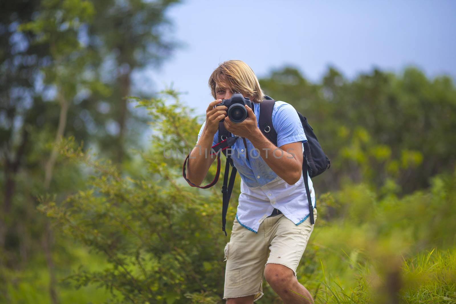 Photographer with Professional Digital Camera Taking Pictures in Nature