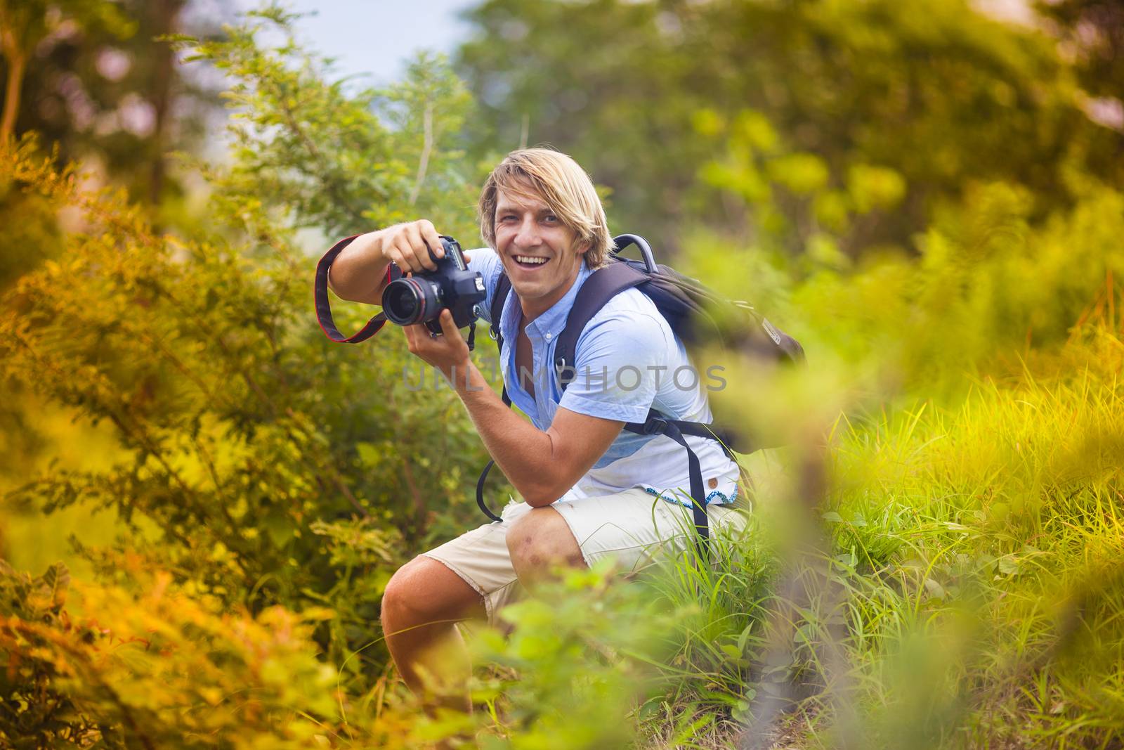 Photographer with Professional Digital Camera Taking Pictures in Nature